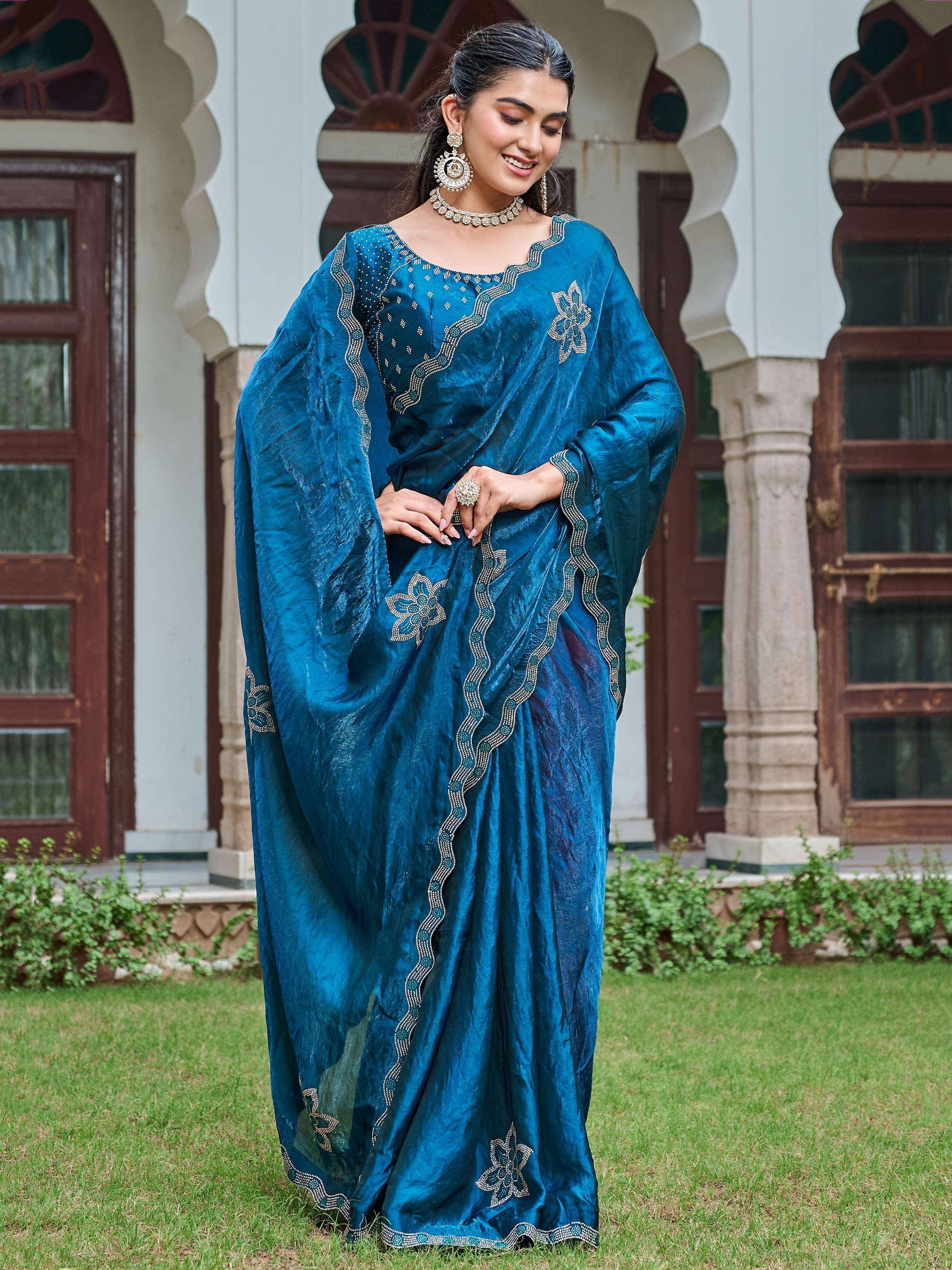 Woman in elegant teal blue embroidered saree with floral motifs, perfect for Indian ethnic occasions.