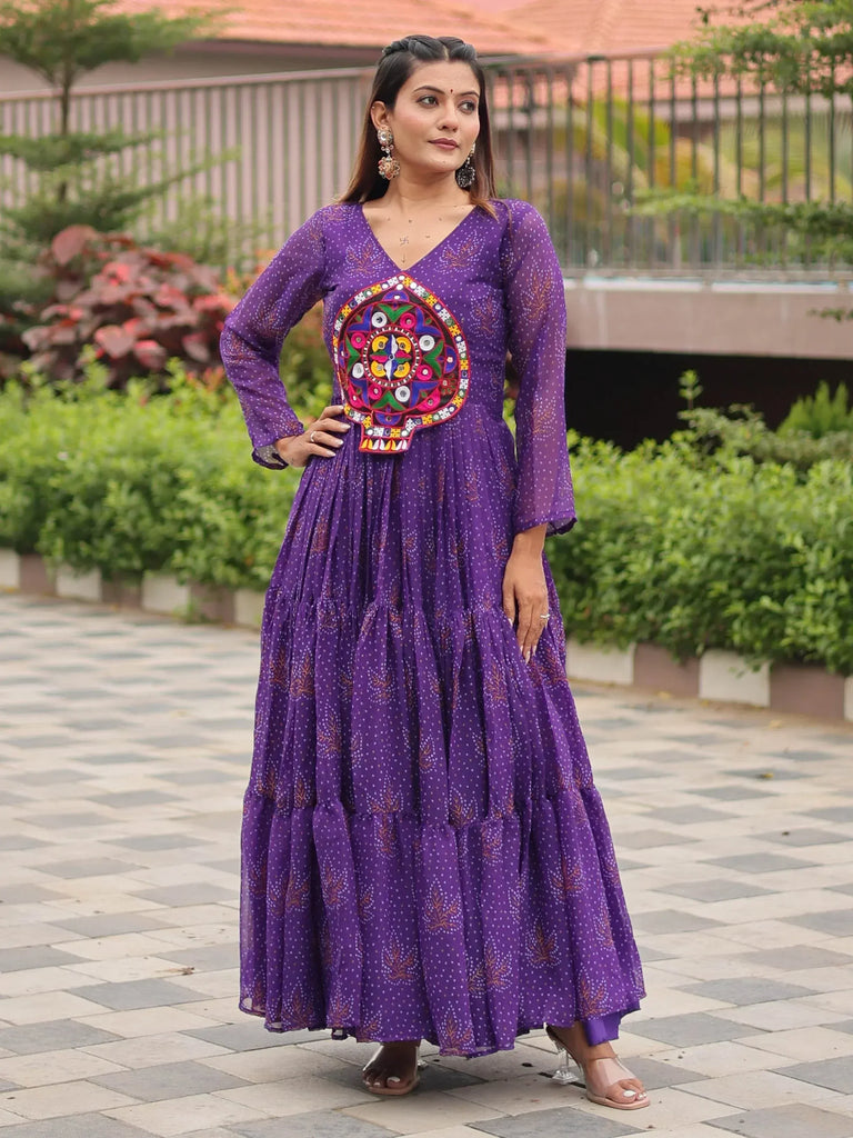 Purple ethnic gown with vibrant mirror work and tiered skirt, perfect for festive occasions