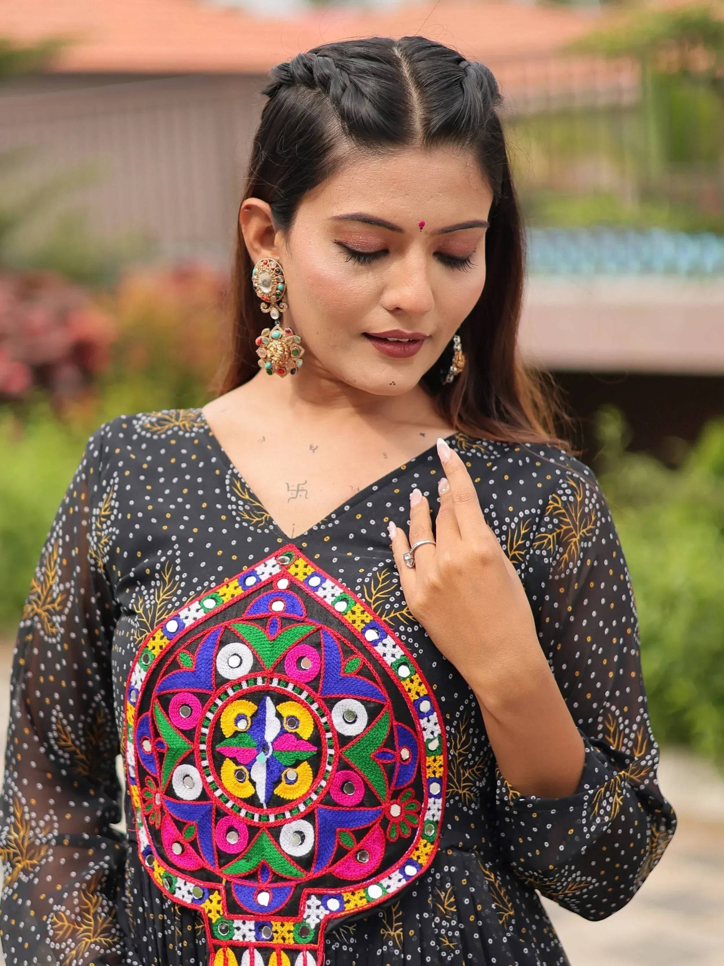 Woman in black ethnic gown with colorful mirror embroidery, traditional Indian wear