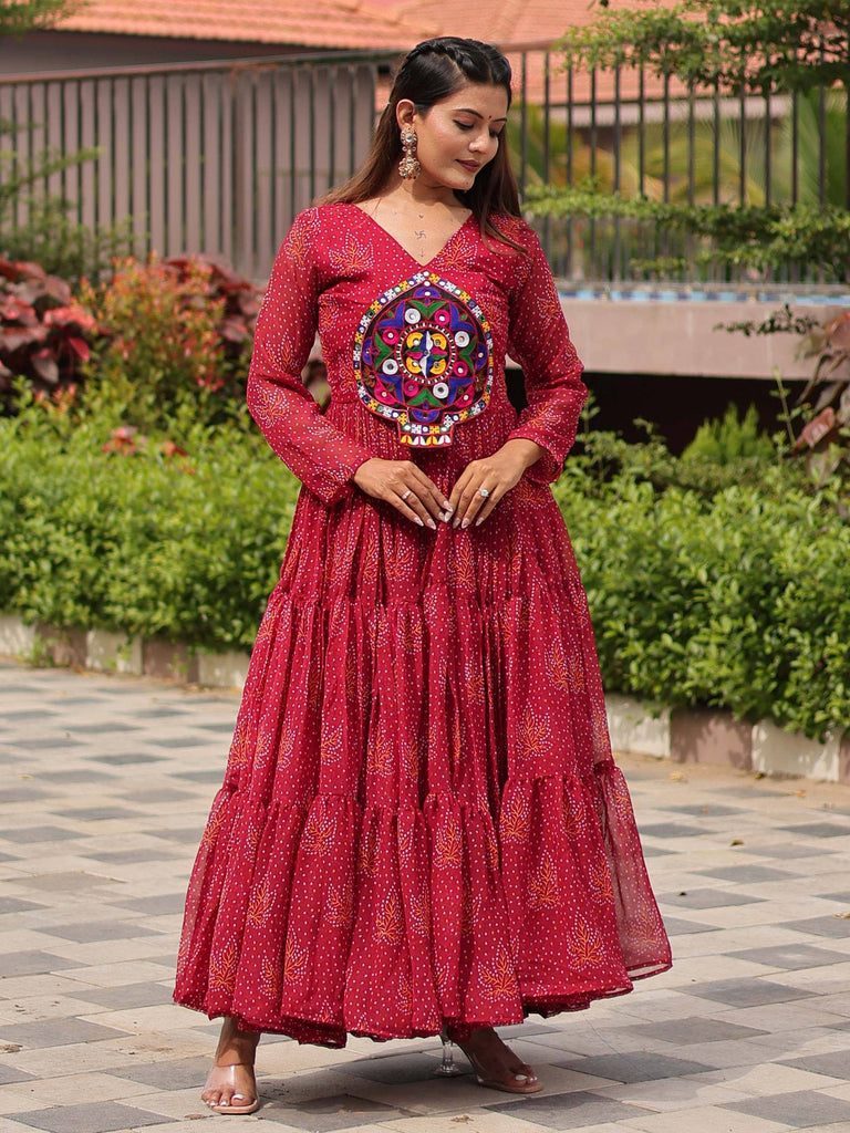 Red ethnic gown with mirror work and printed motifs, perfect for Indian festive occasions