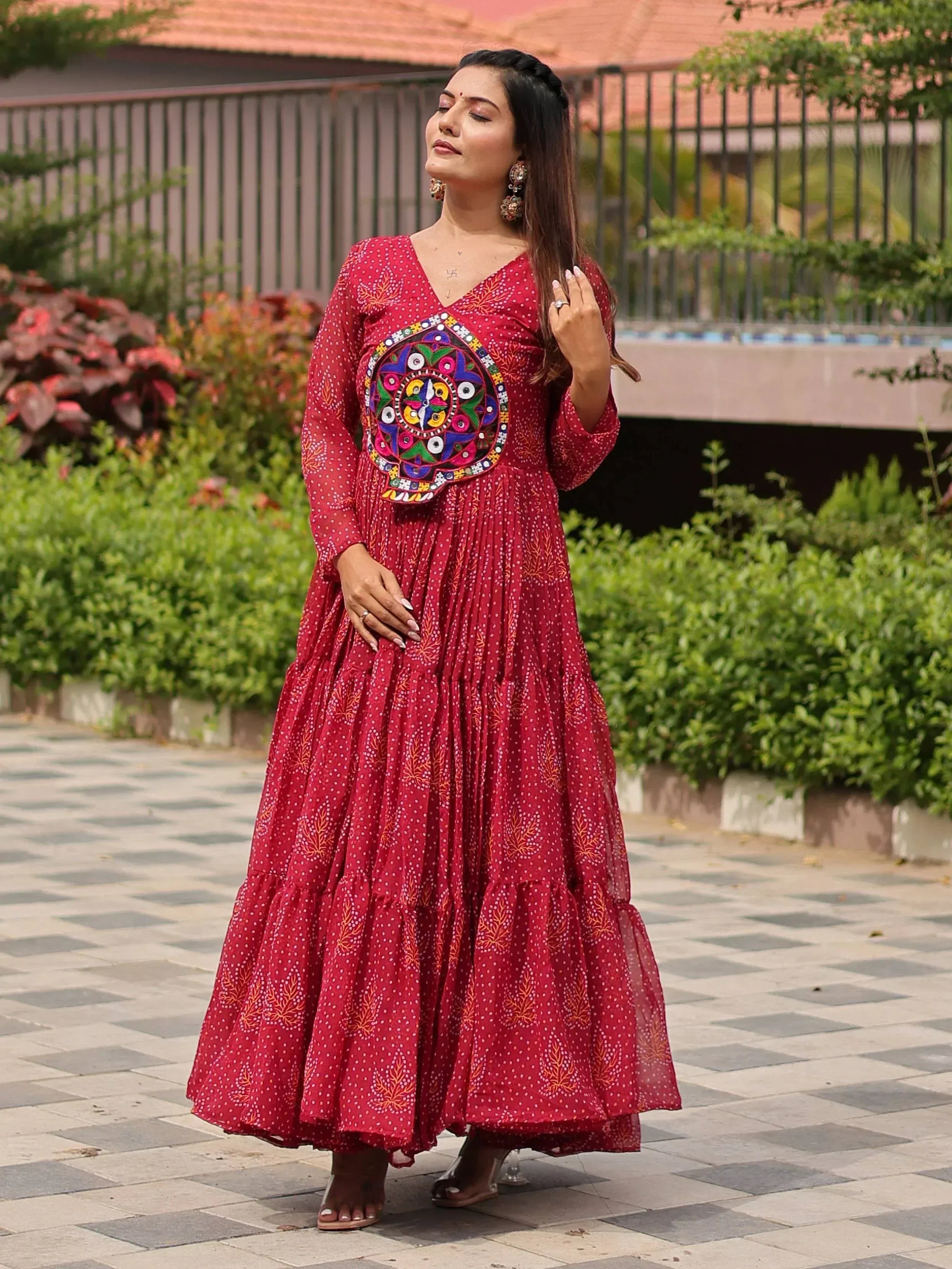 Red ethnic gown with mirror work and printed motifs, perfect for Indian occasions