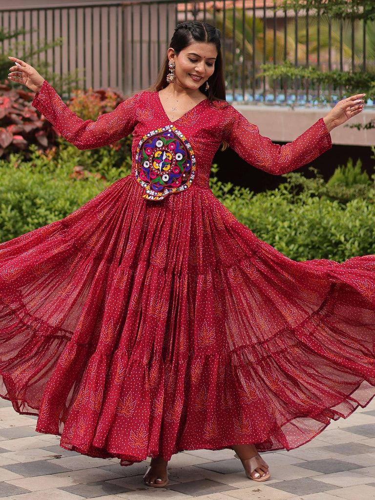 Woman twirling in red ethnic gown with mirror work, perfect for Indian festivals and occasions.