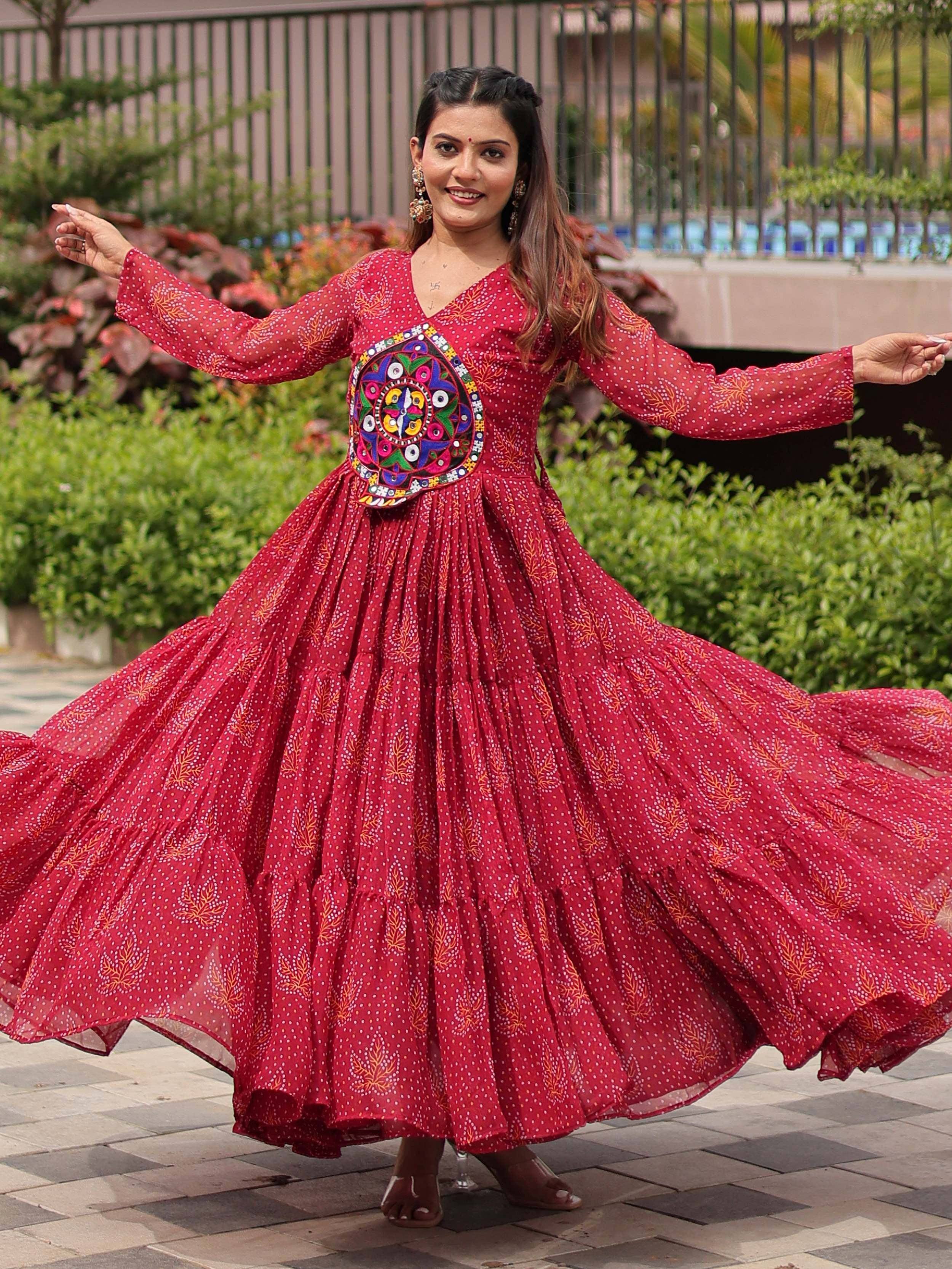 Woman twirling in red ethnic gown with mirror work, perfect for Indian festive occasions and celebrations.