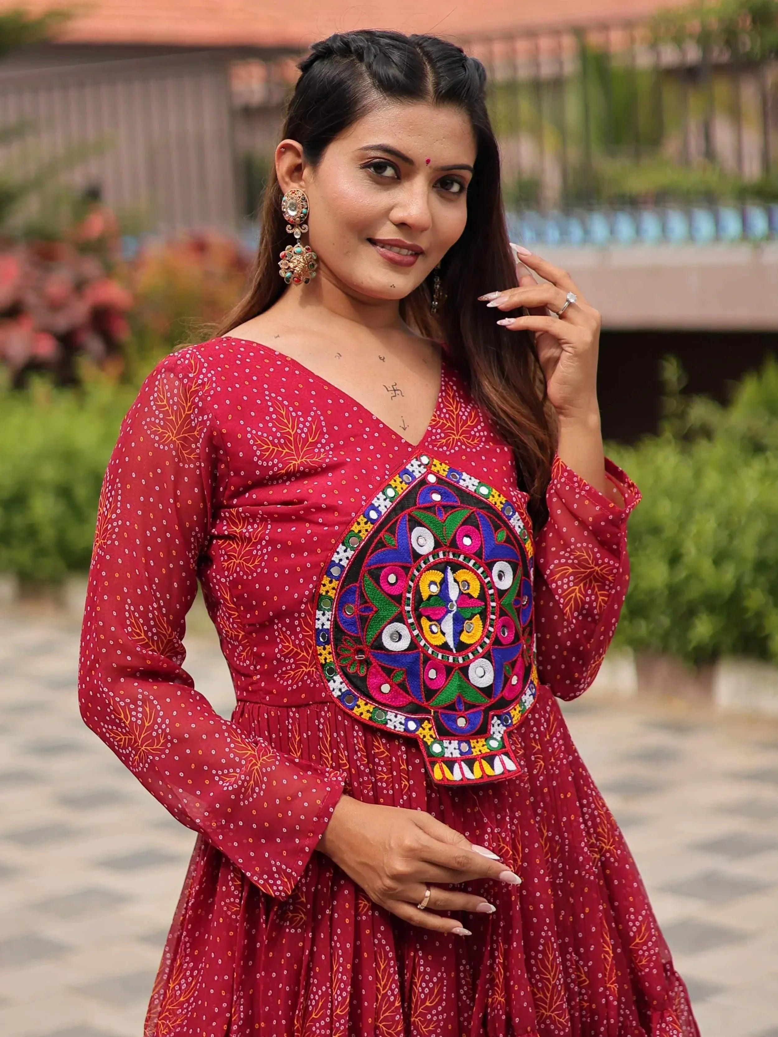 Woman in red ethnic gown with colorful mirror embroidery, perfect for Indian festive occasions