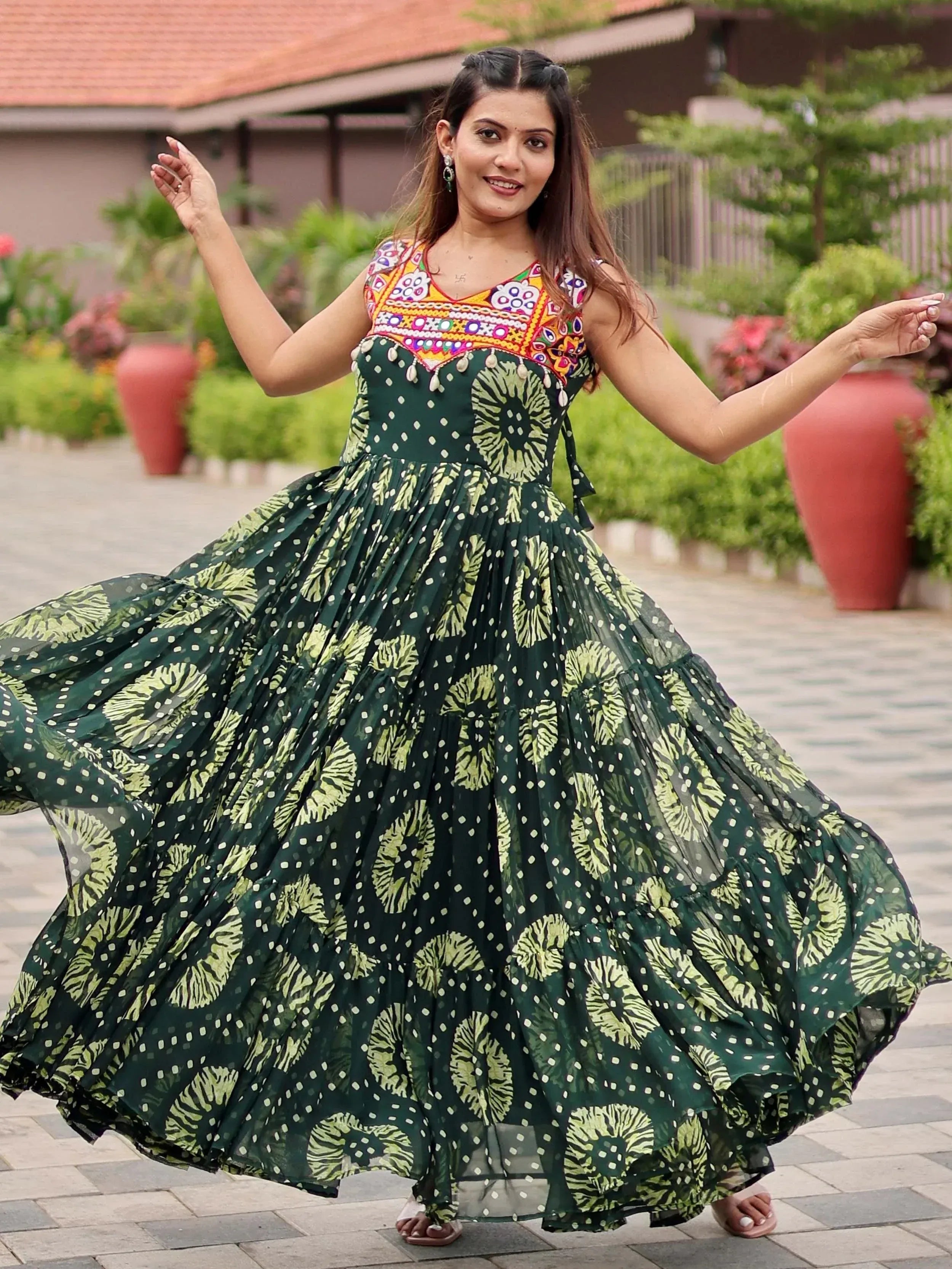 Woman twirling in green floral ethnic gown with embroidered neckline, perfect for Indian festive occasions.