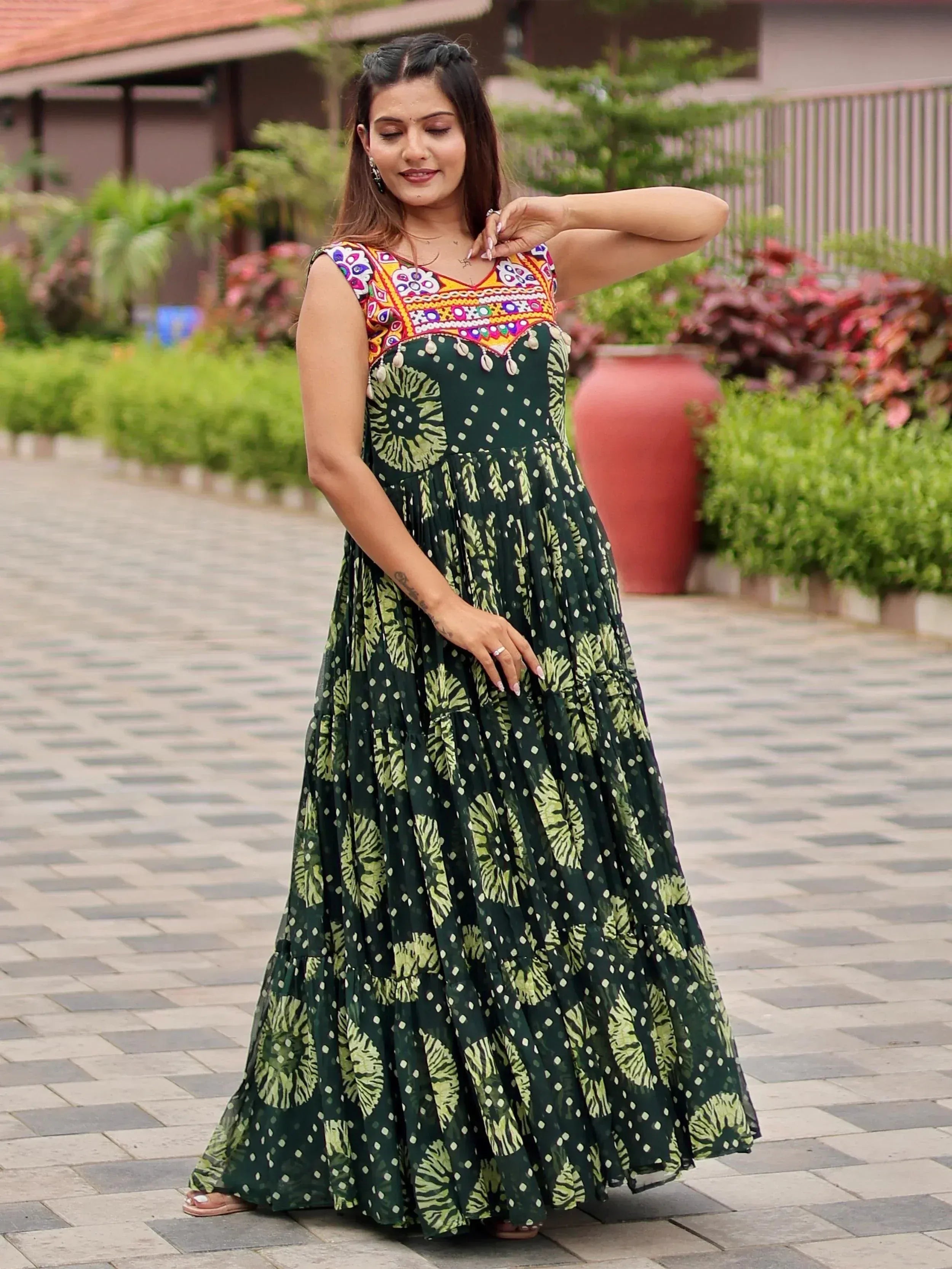Woman in green floral ethnic gown with colorful embroidered neckline, perfect for Indian occasions.