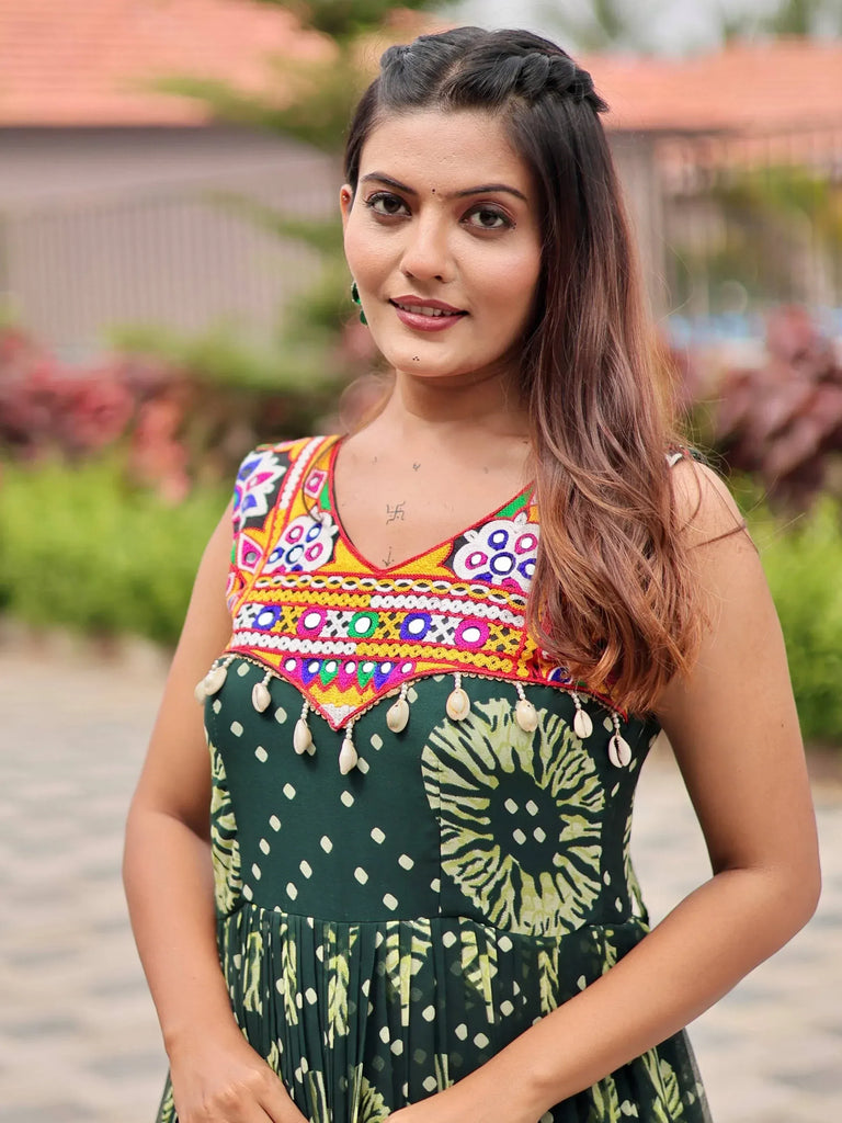 Woman in green printed ethnic gown with colorful mirror work and shell embellishments
