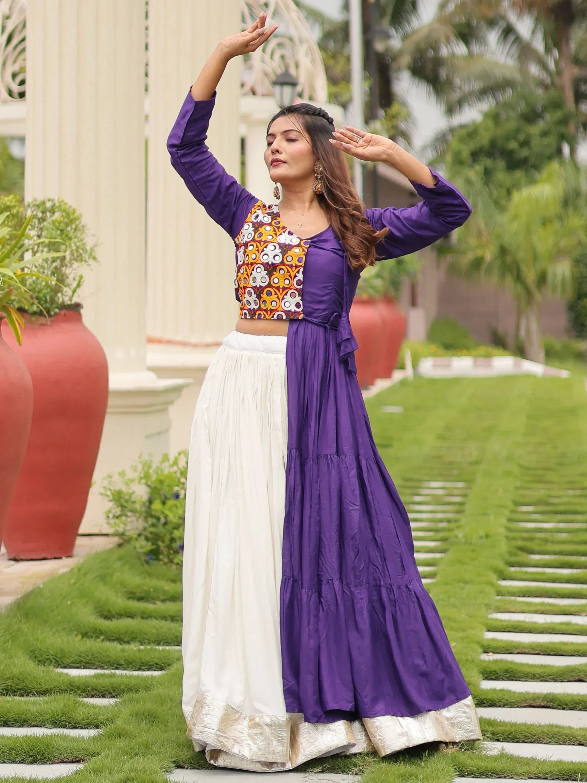 Woman in purple and white ethnic lehenga choli with embroidered crop top, posing outdoors