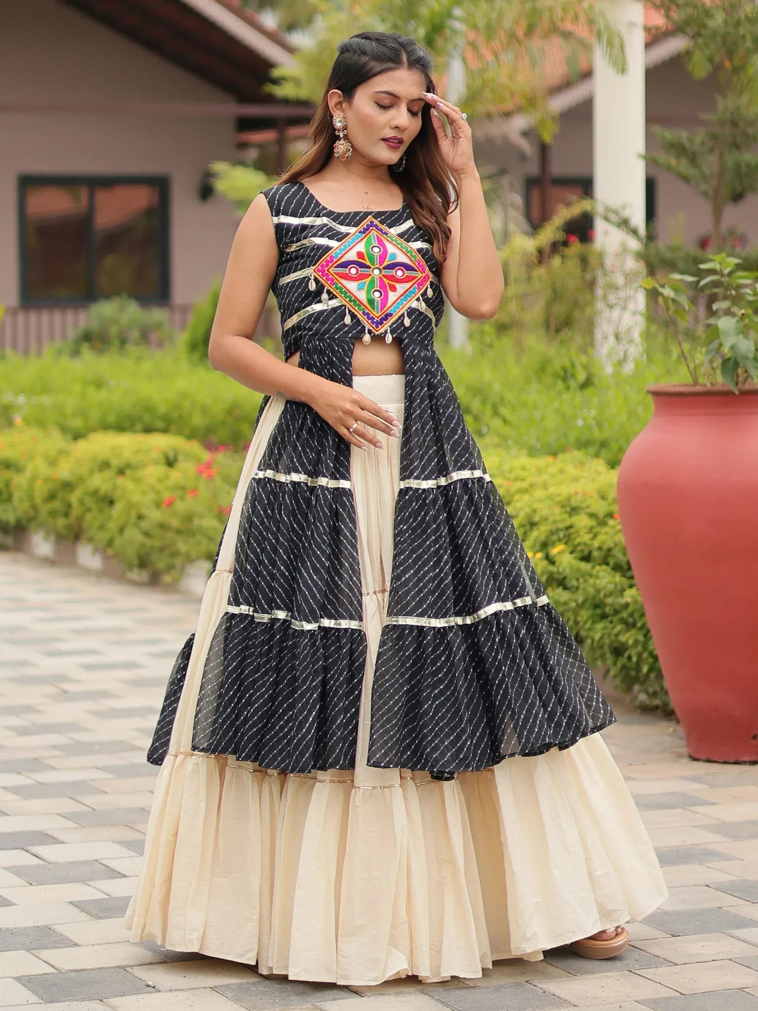 Black and cream ethnic lehenga with colorful mirror work and tiered skirt, perfect for Indian festive occasions