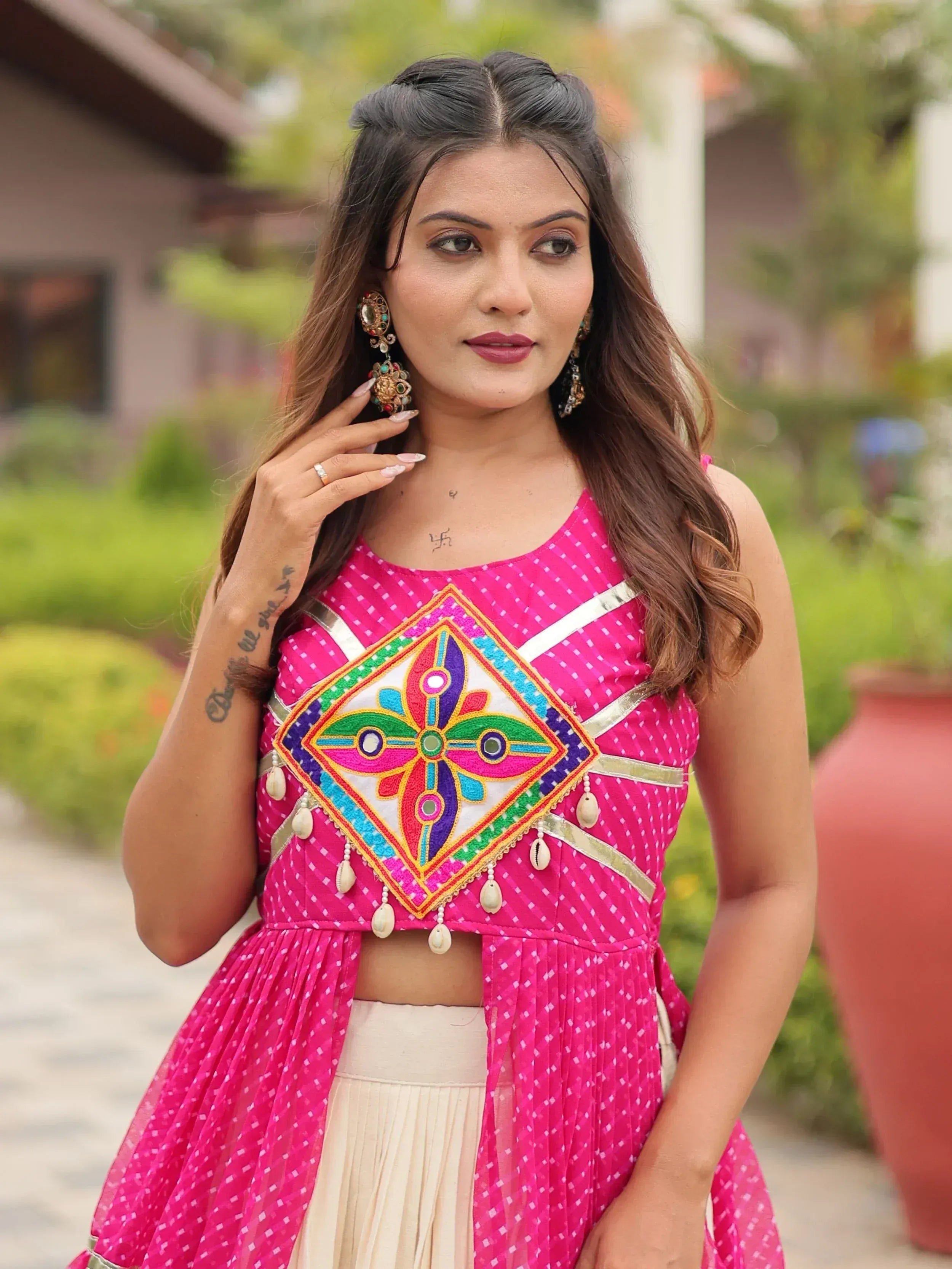 Pink ethnic crop top with mirror work and shell embellishments, paired with cream skirt