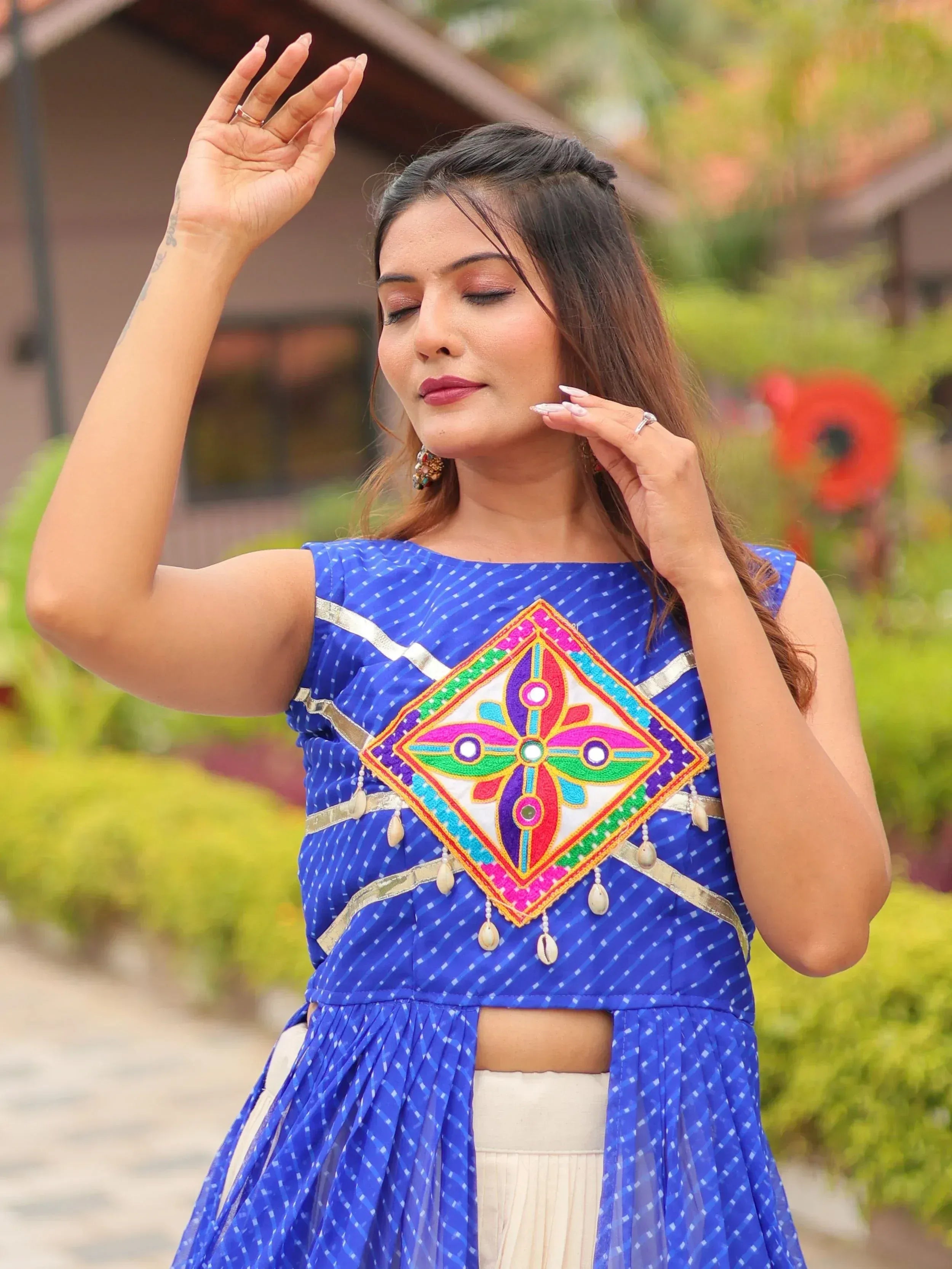 Blue ethnic crop top with colorful mirror work and shell tassels, paired with cream skirt