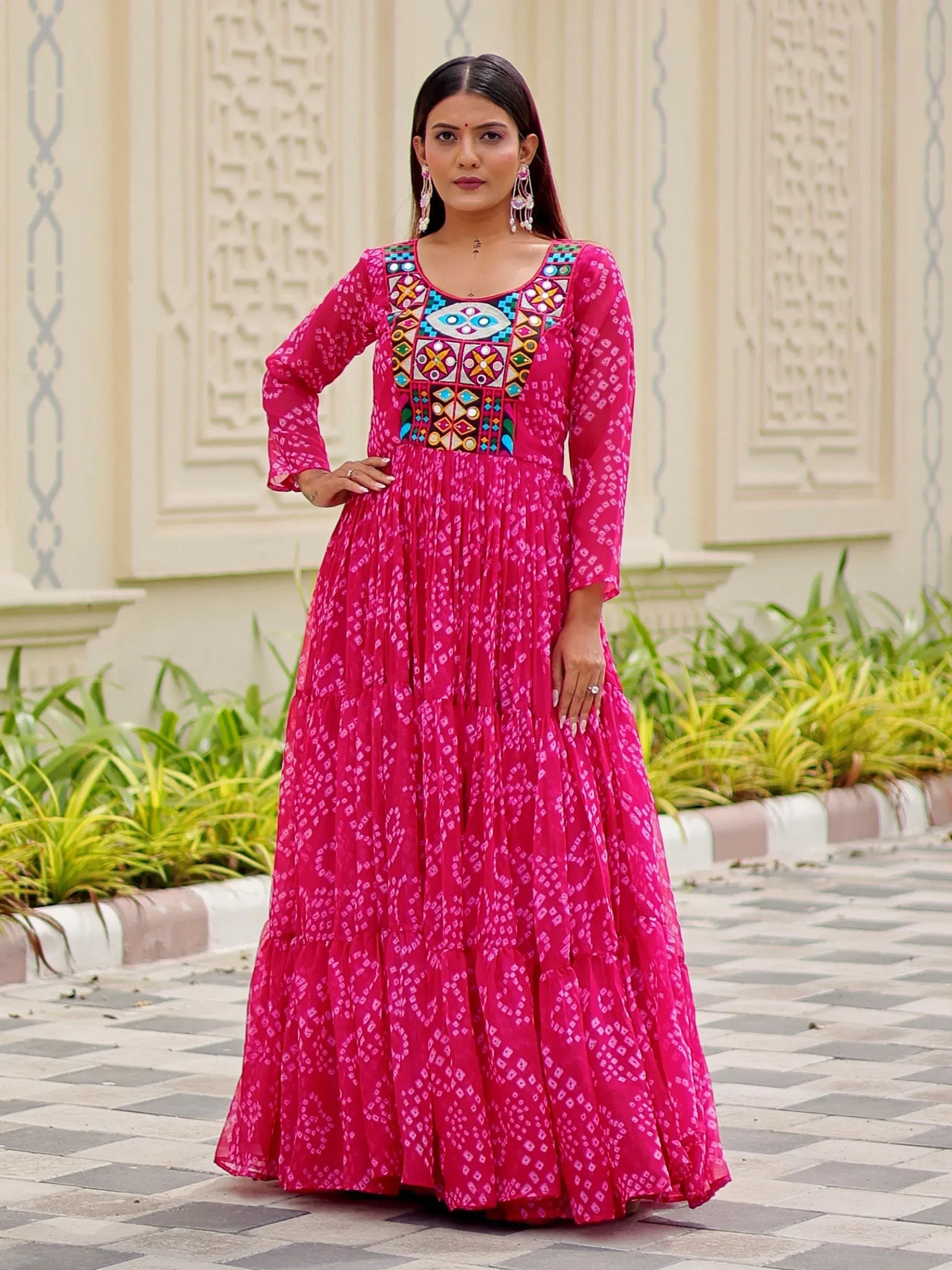 Vibrant pink ethnic gown with colorful embroidery and geometric patterns, perfect for festive occasions.