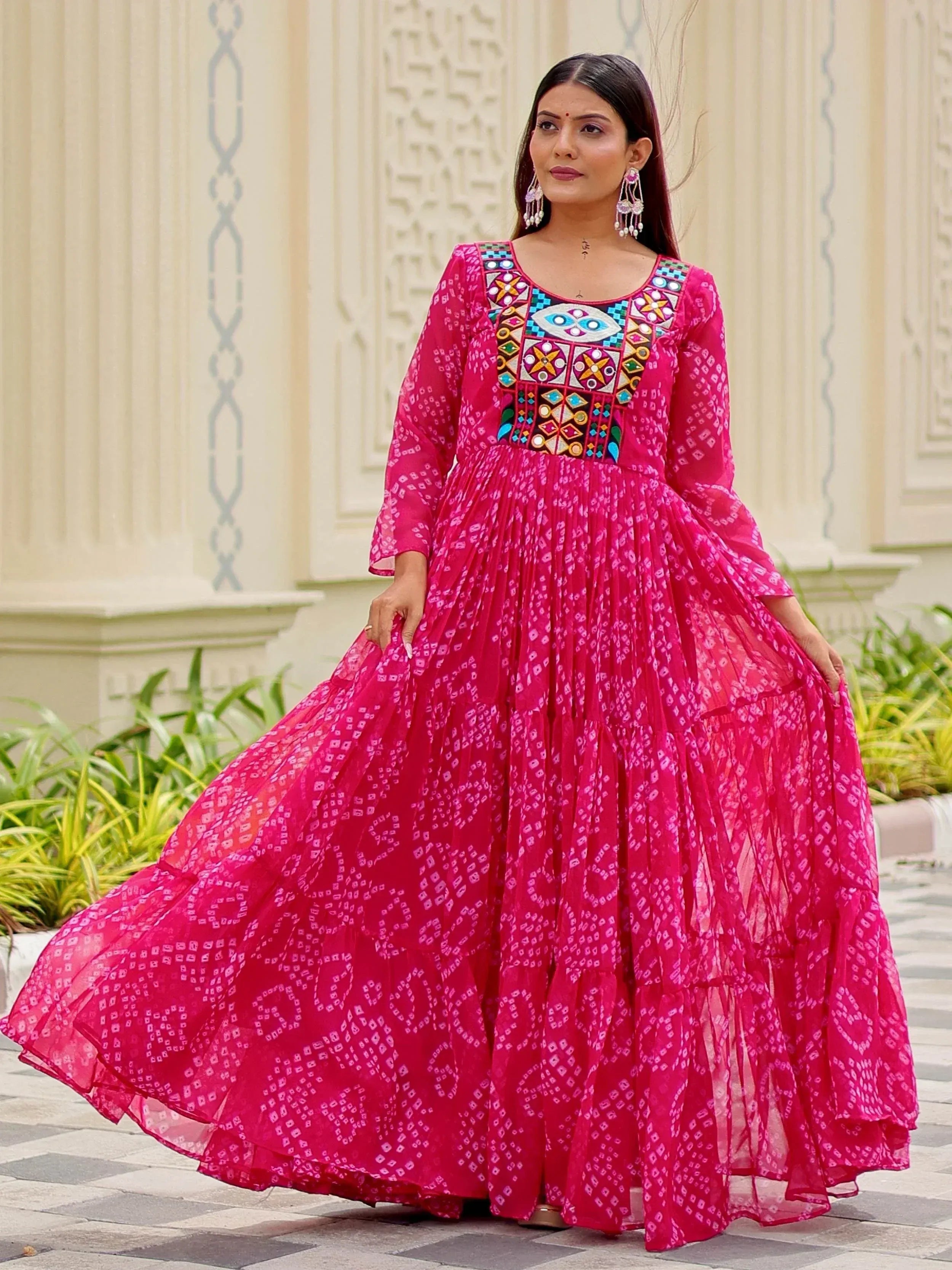 Pink ethnic gown with mirror work and tiered skirt, perfect for Indian occasions