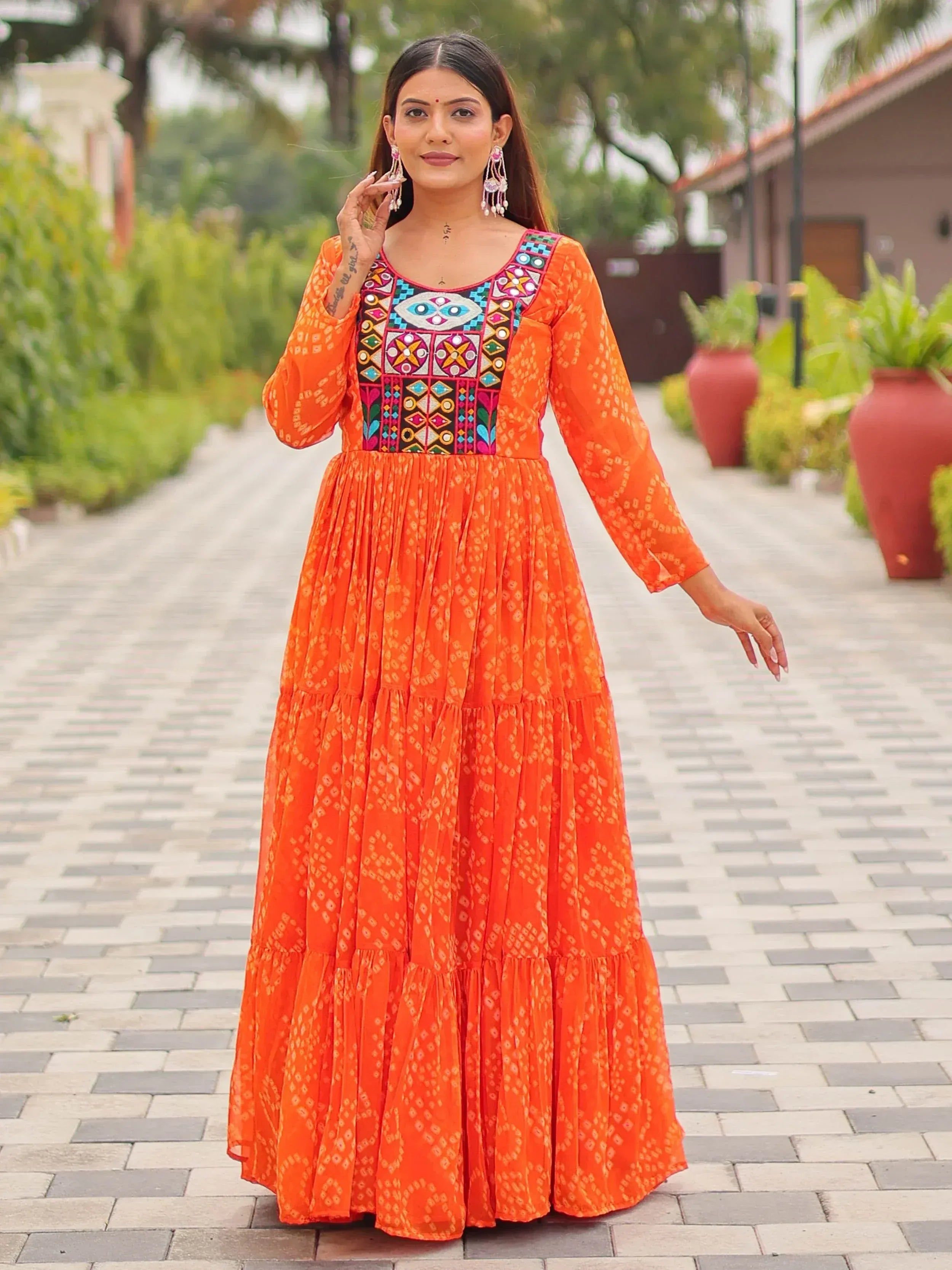 Orange ethnic gown with colorful embroidery, perfect for Indian occasions and festive wear.
