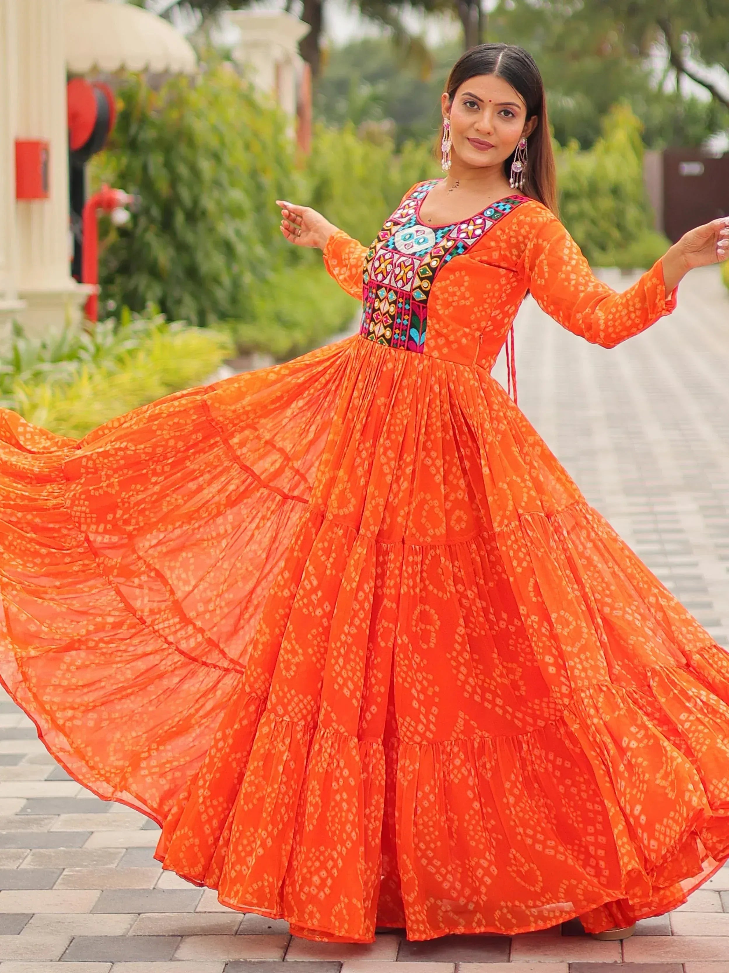 Vibrant orange ethnic gown with colorful embroidery, perfect for Indian festive occasions and celebrations.