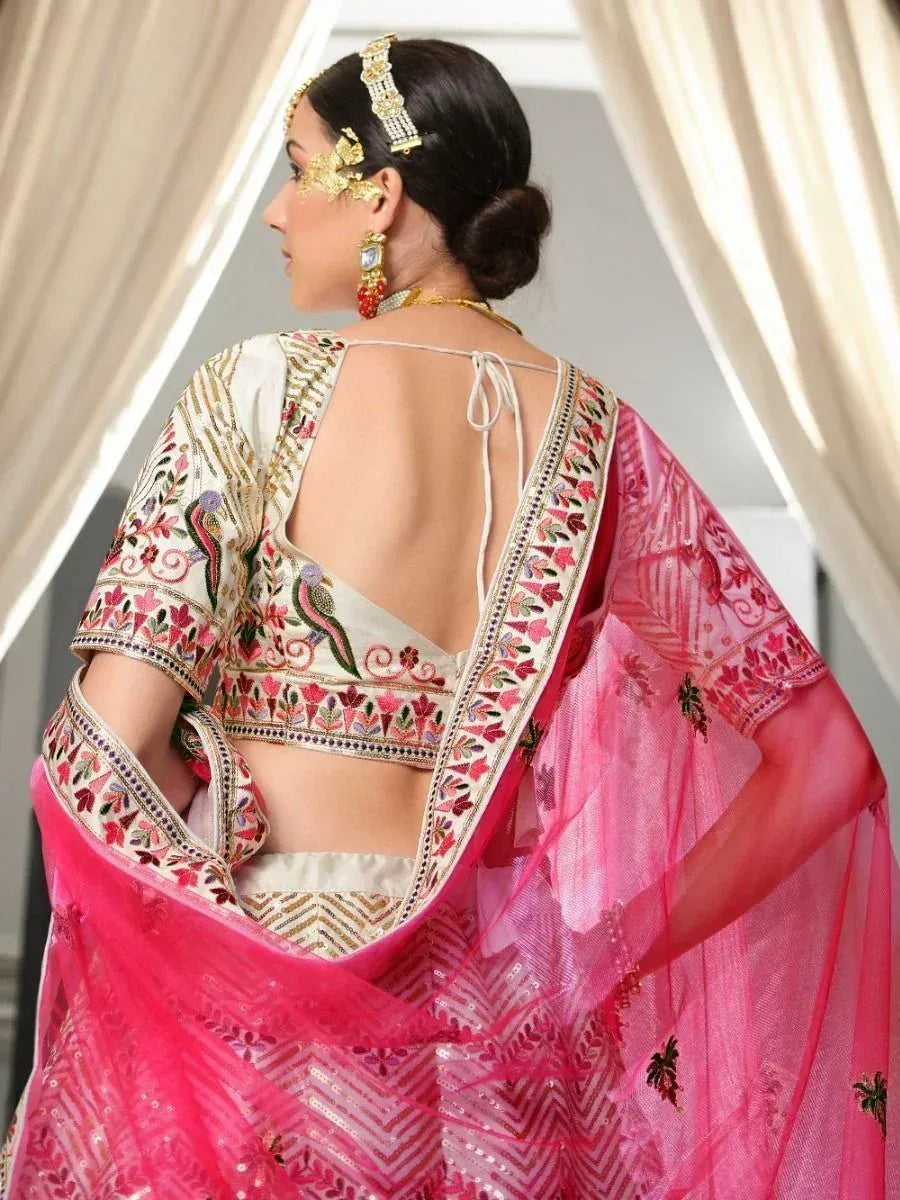 Pink embroidered lehenga choli with open back blouse, floral motifs, and gold jewelry for Indian ethnic wear