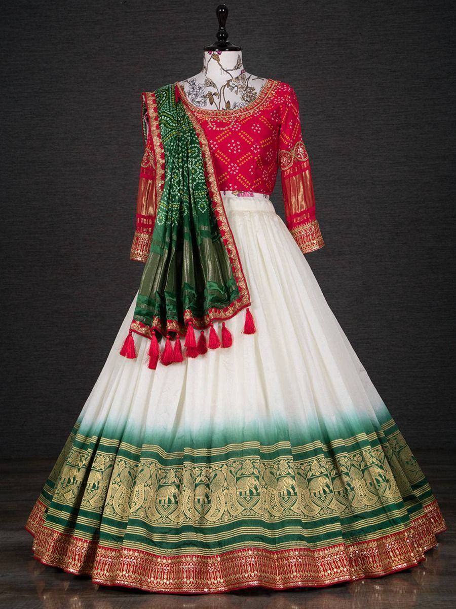 Red and white lehenga choli with green dupatta, gold embroidery, and tassels for Indian ethnic wear