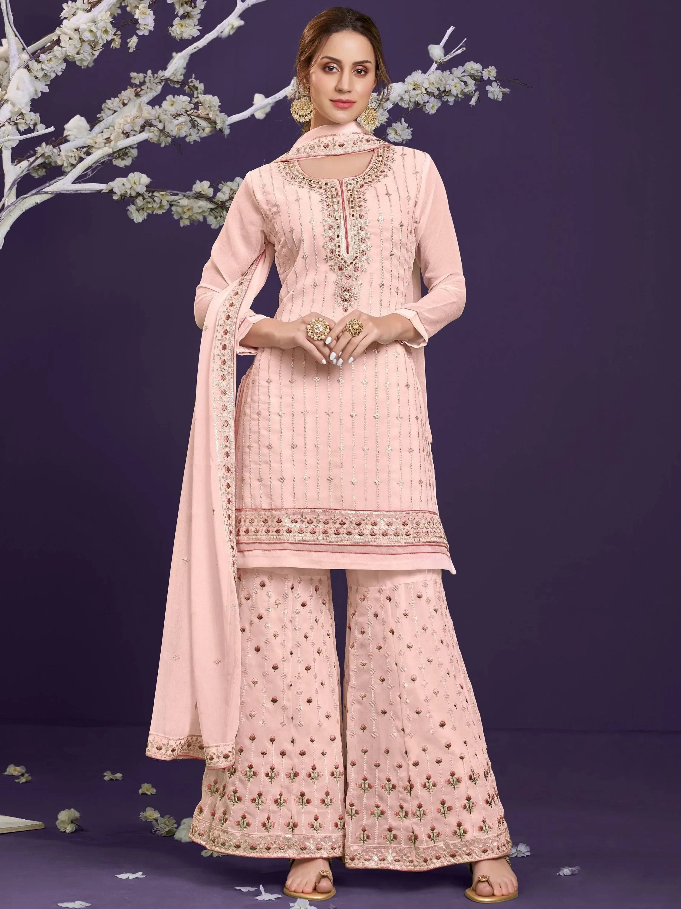Woman wearing pastel pink embroidered palazzo suit with dupatta, ethnic Indian outfit