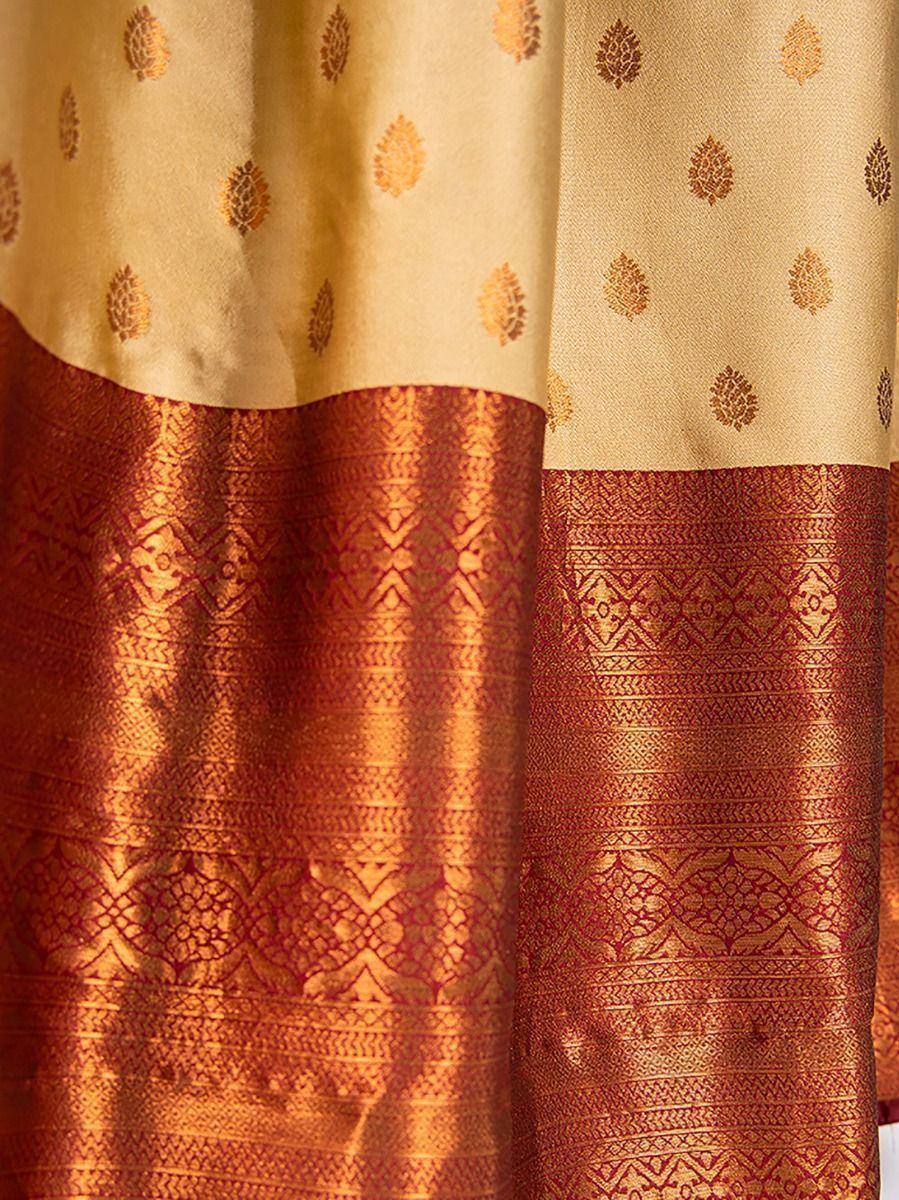 Gold and maroon ethnic saree with intricate leaf motifs and woven border design