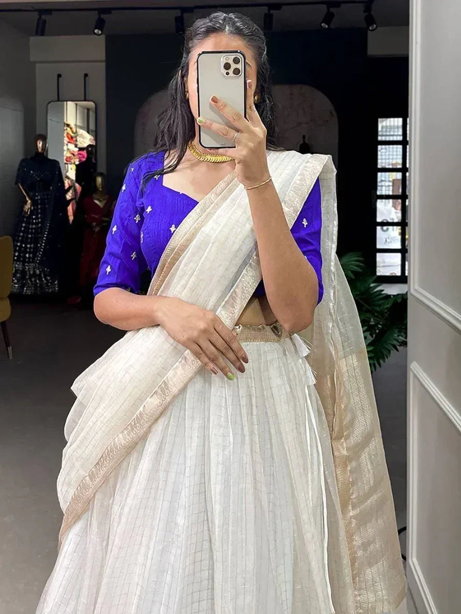 Woman in white saree with gold border and royal blue blouse, ethnic Indian wear