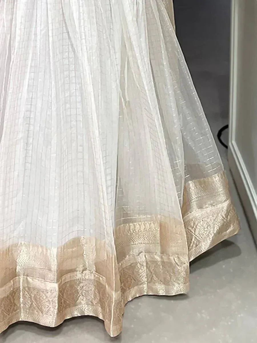 White ethnic gown with gold embroidered border, perfect for Indian occasions
