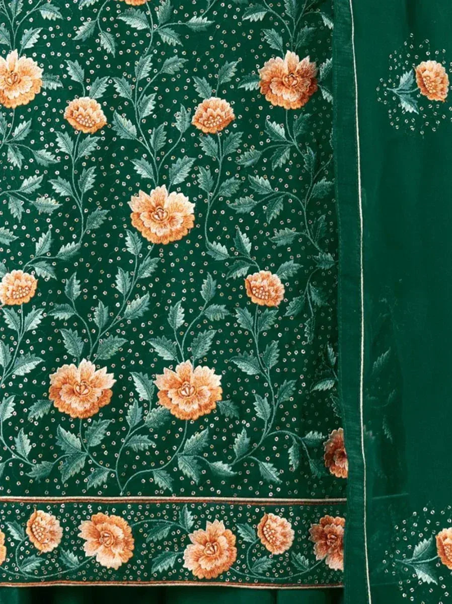 Green ethnic fabric with orange floral embroidery and detailed leafy patterns