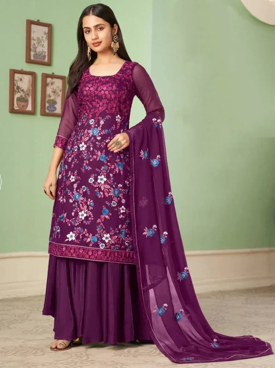 Woman wearing a purple floral embroidered Indian ethnic suit with matching dupatta and sharara