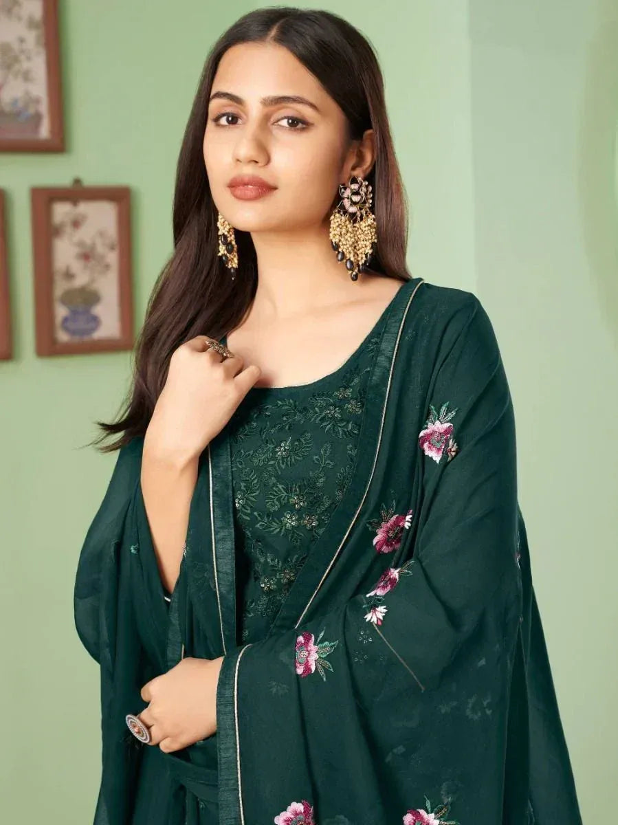 Woman in embroidered green salwar kameez with floral dupatta and statement earrings