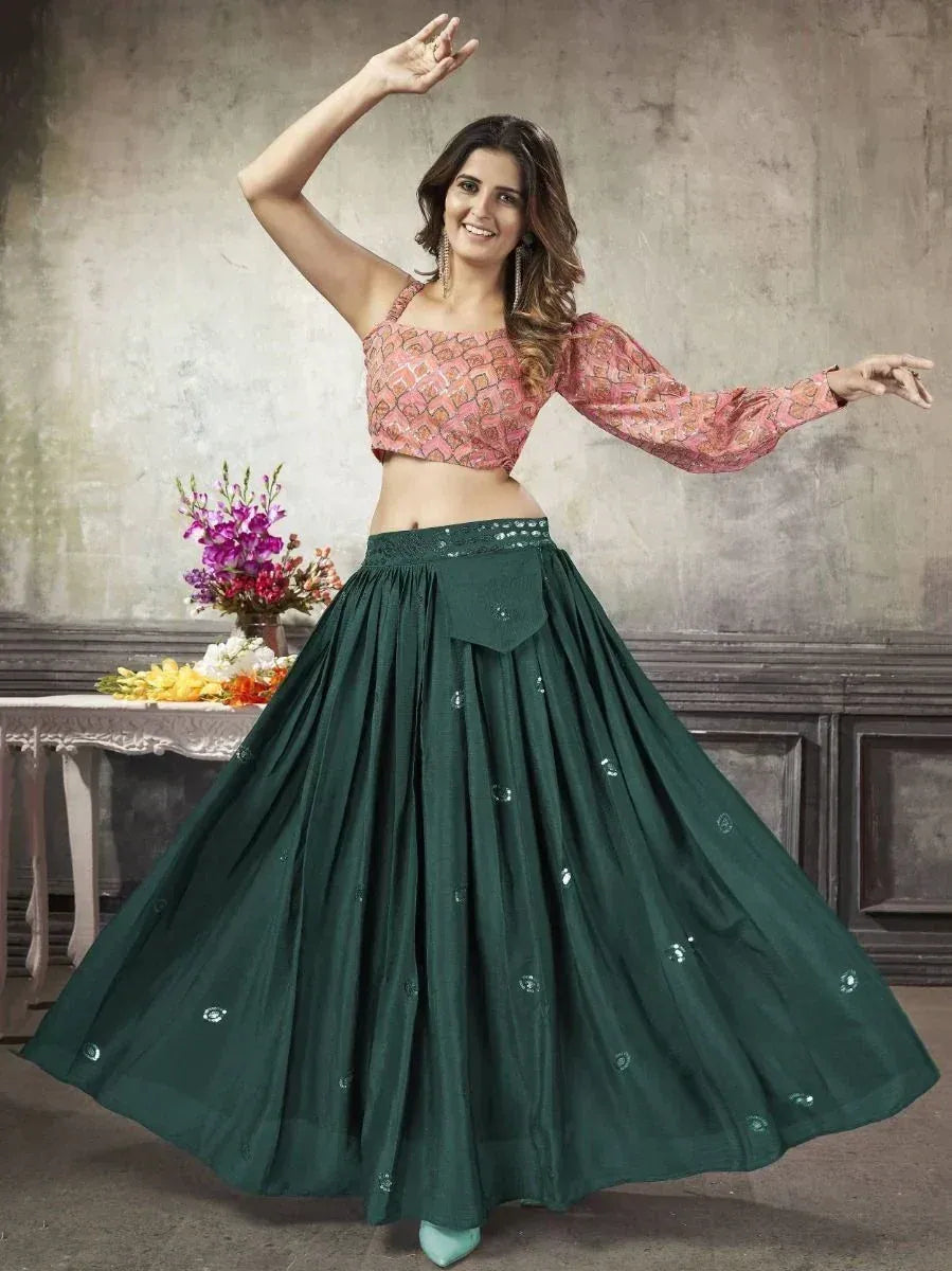 Woman in pink printed crop top and green lehenga skirt, dancing gracefully for ethnic wear collection