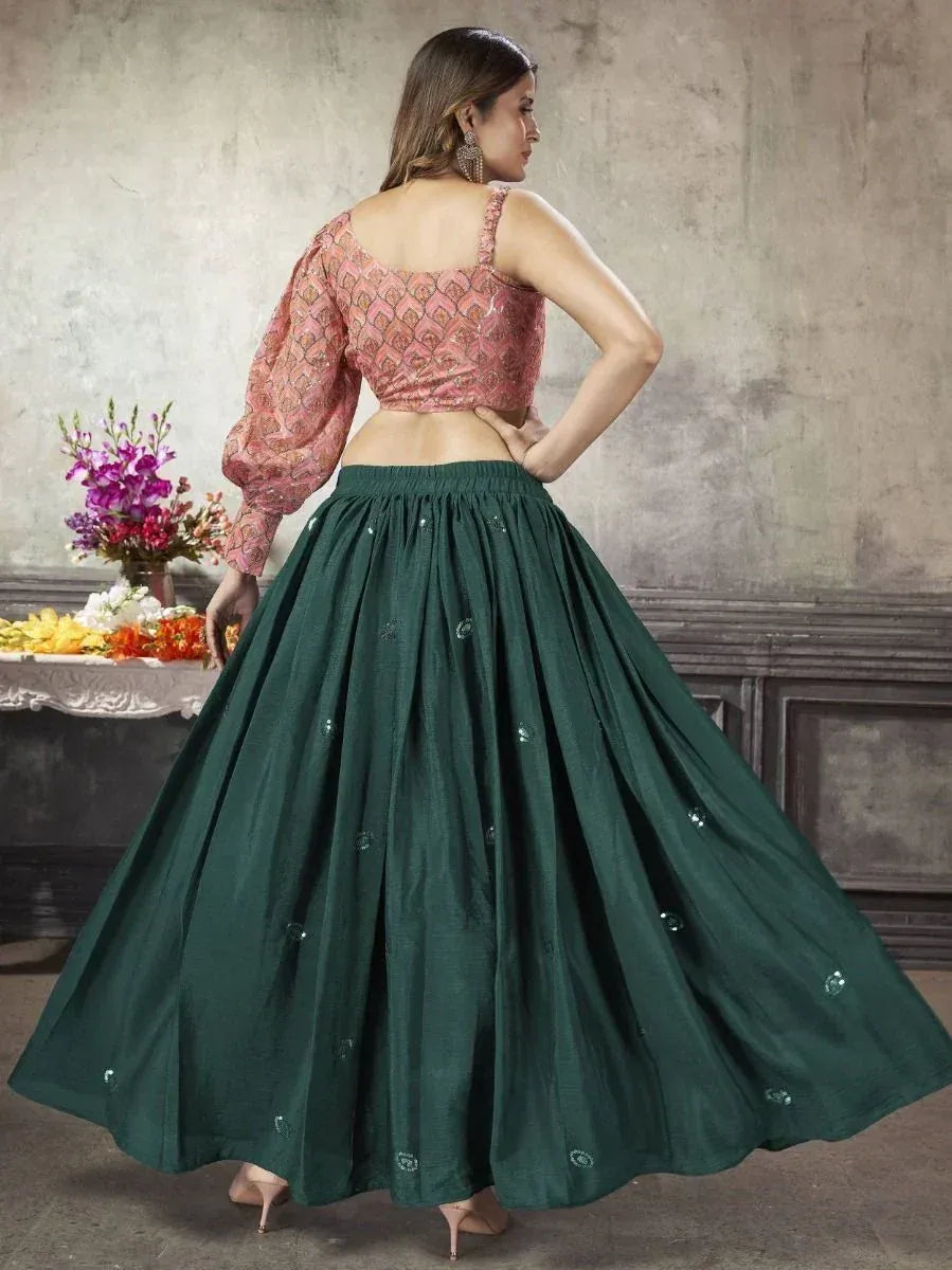 Woman in pink embroidered blouse and green lehenga skirt, showcasing Indian ethnic wear