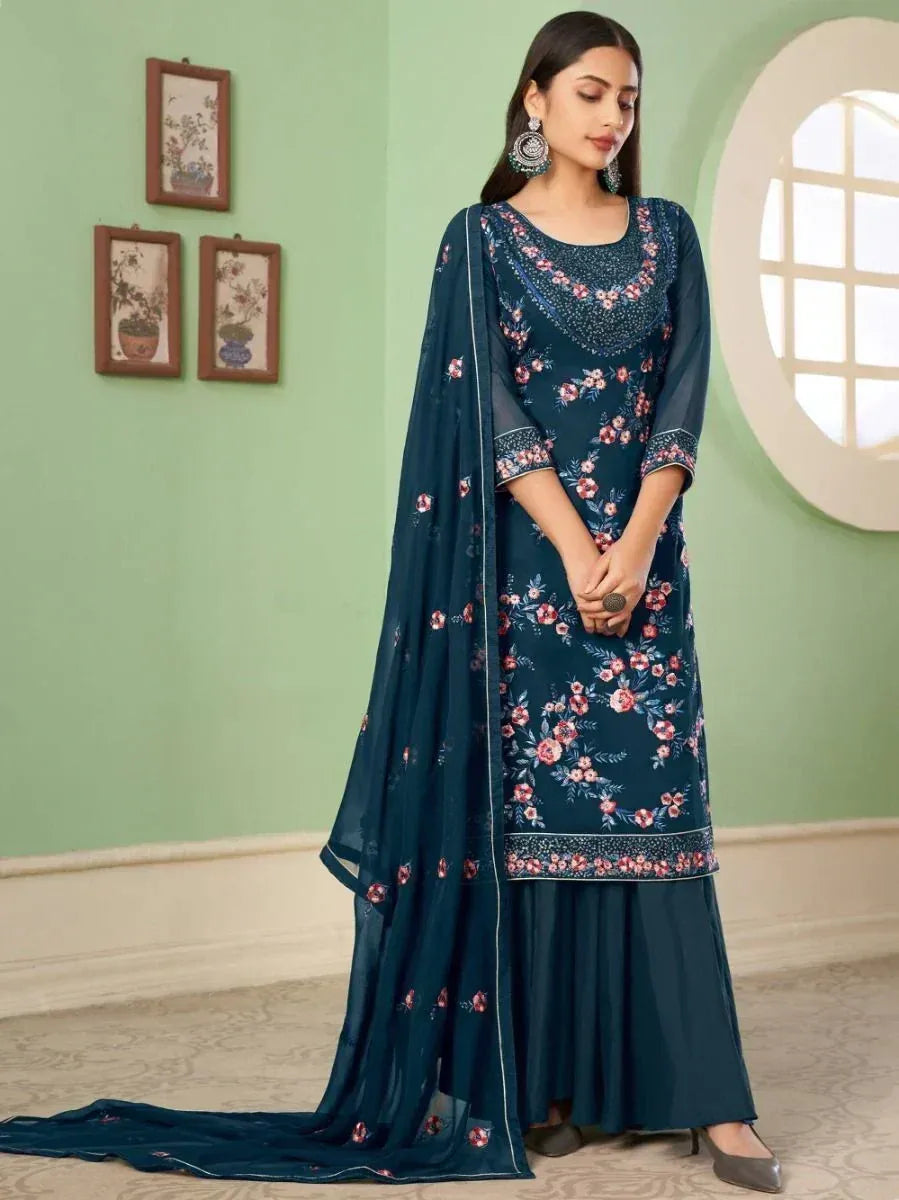 Woman wearing teal floral embroidered salwar kameez with matching dupatta