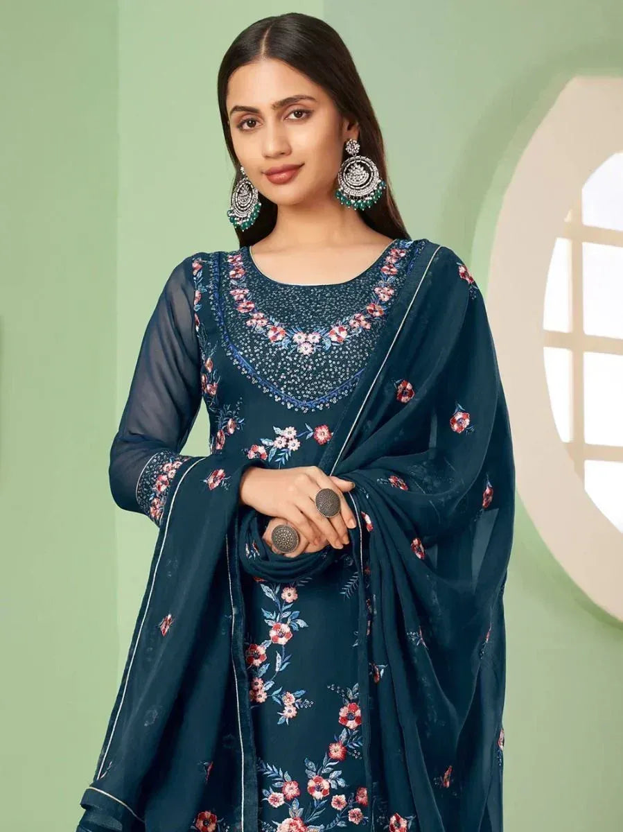Woman wearing navy blue floral salwar kameez with sheer sleeves and statement earrings