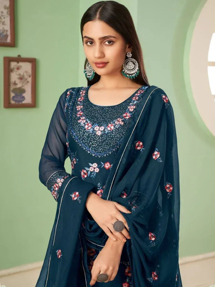 Woman wearing a navy blue floral embroidered salwar kameez with net sleeves and dupatta