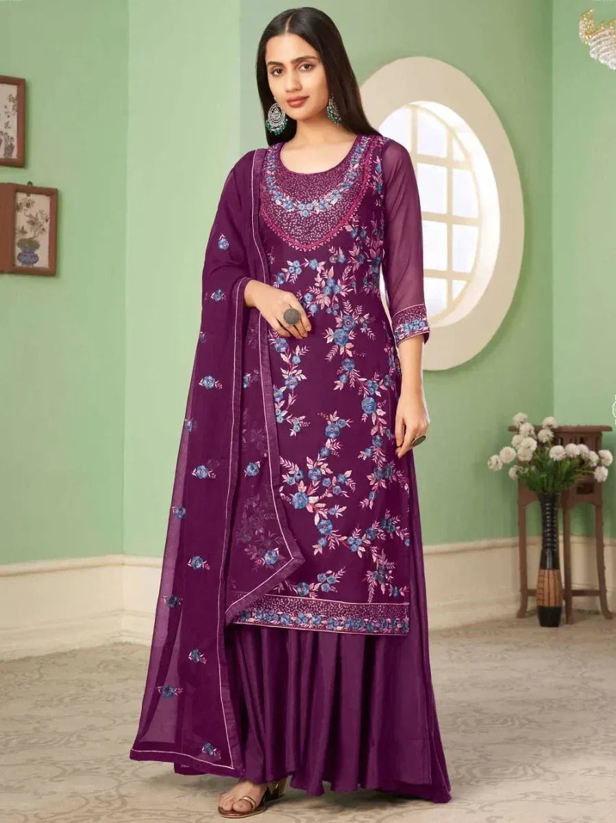 Woman wearing a purple embroidered salwar kameez with floral patterns and matching dupatta