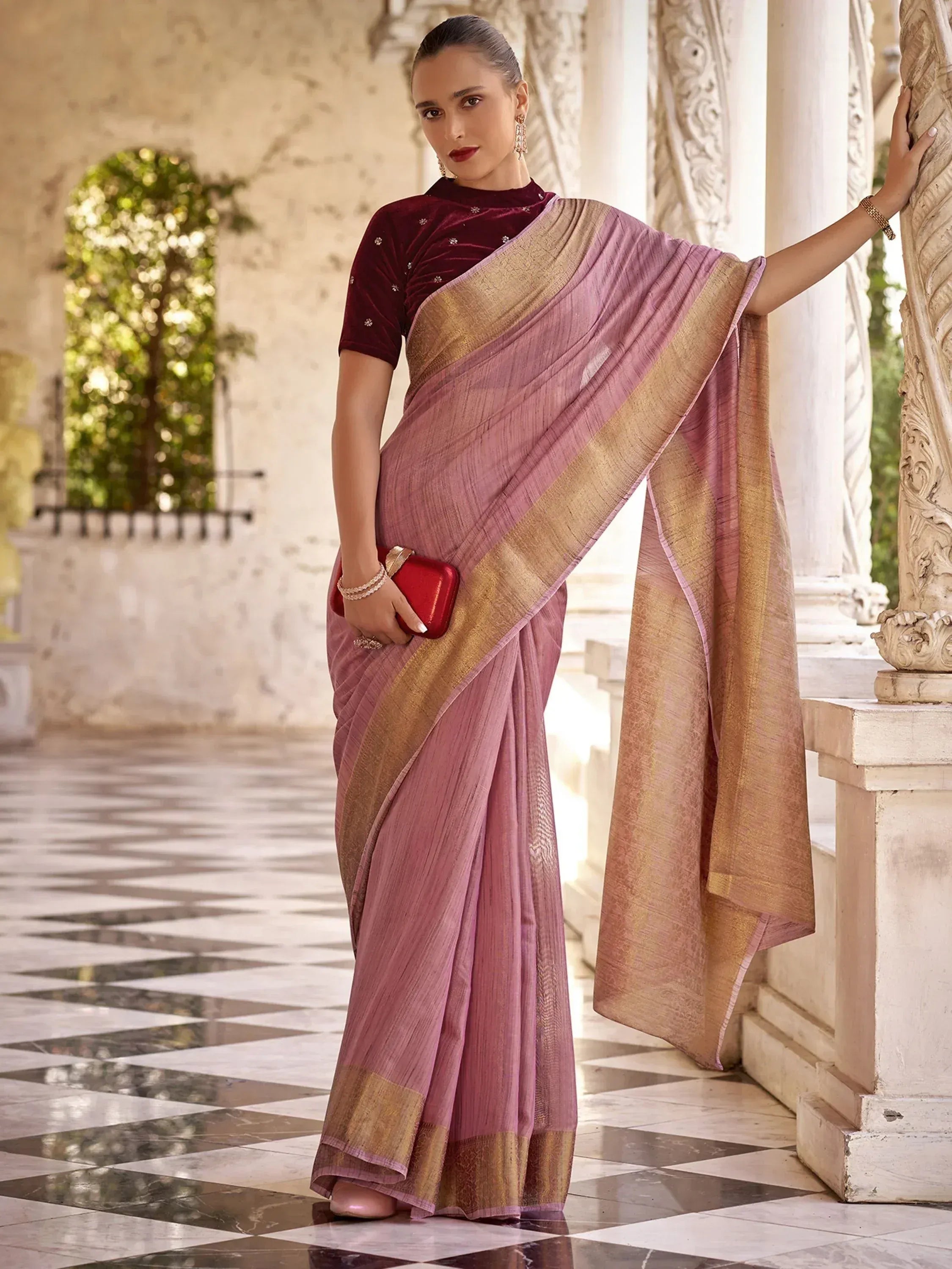 Woman in elegant pink saree with gold border and maroon velvet blouse, perfect for Indian ethnic occasions