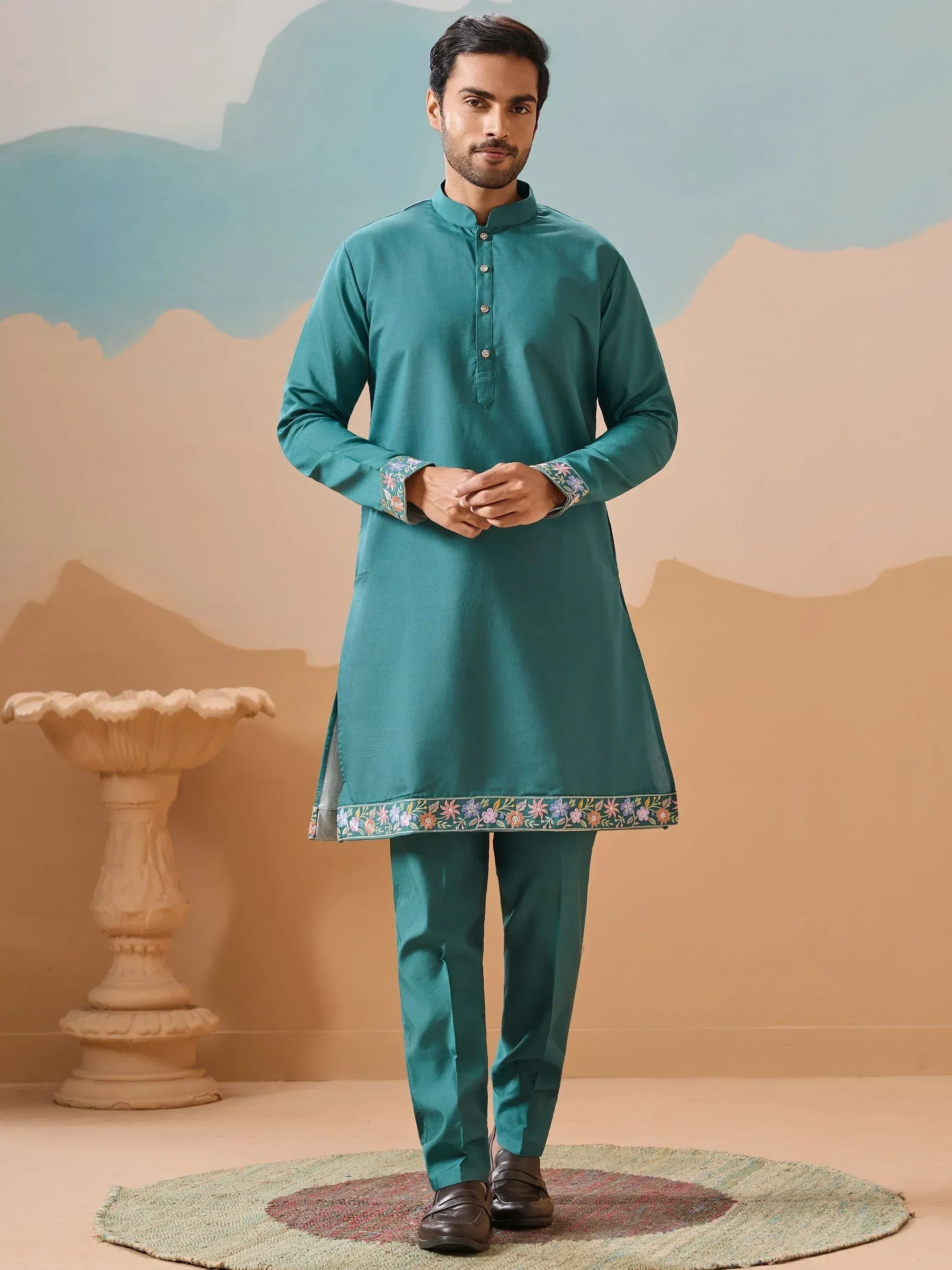 Teal men's kurta with floral embroidery, paired with matching pants for ethnic wear occasions