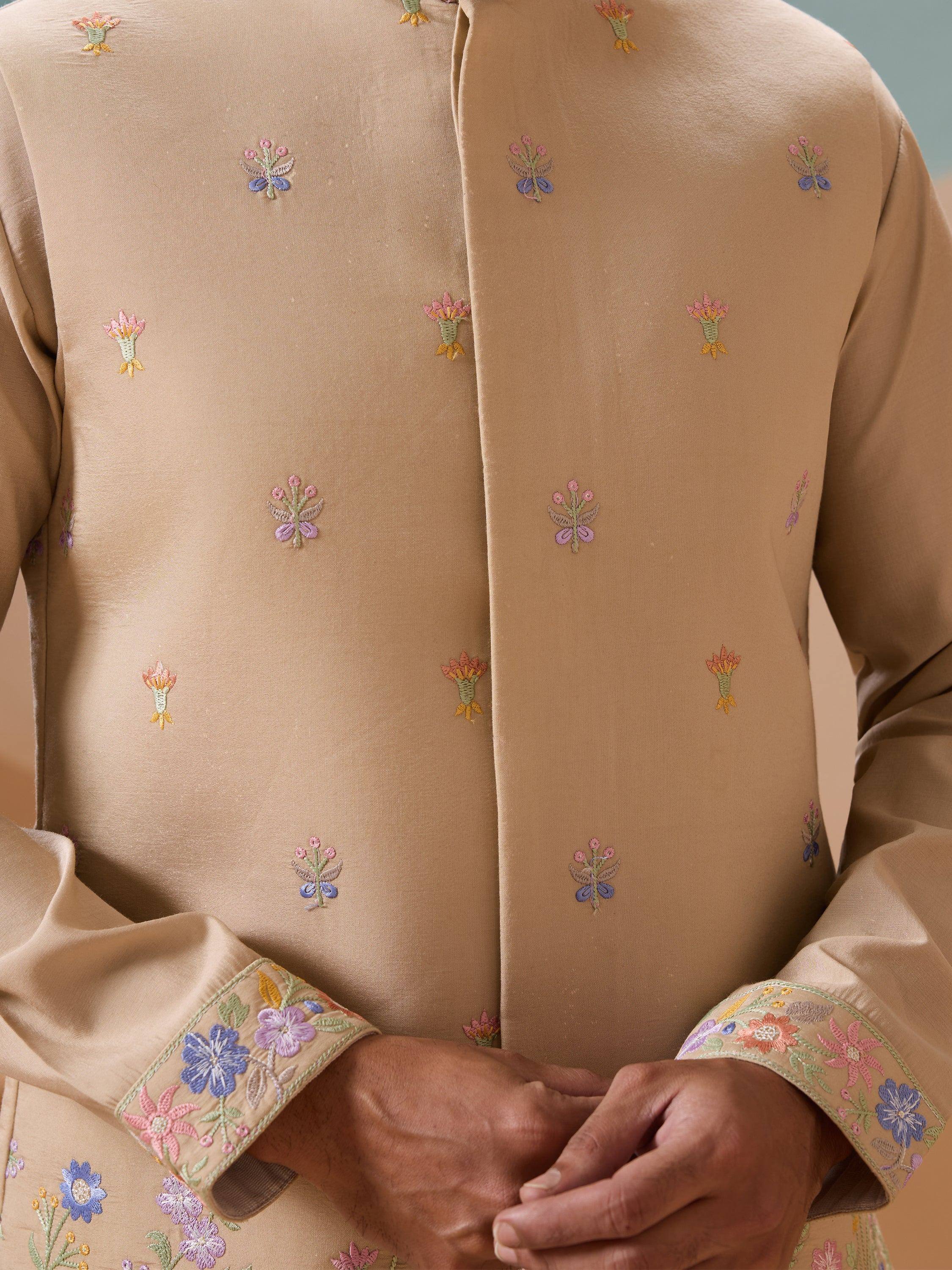 Beige ethnic kurta with colorful floral embroidery and detailed cuffs, perfect for Indian festive wear.