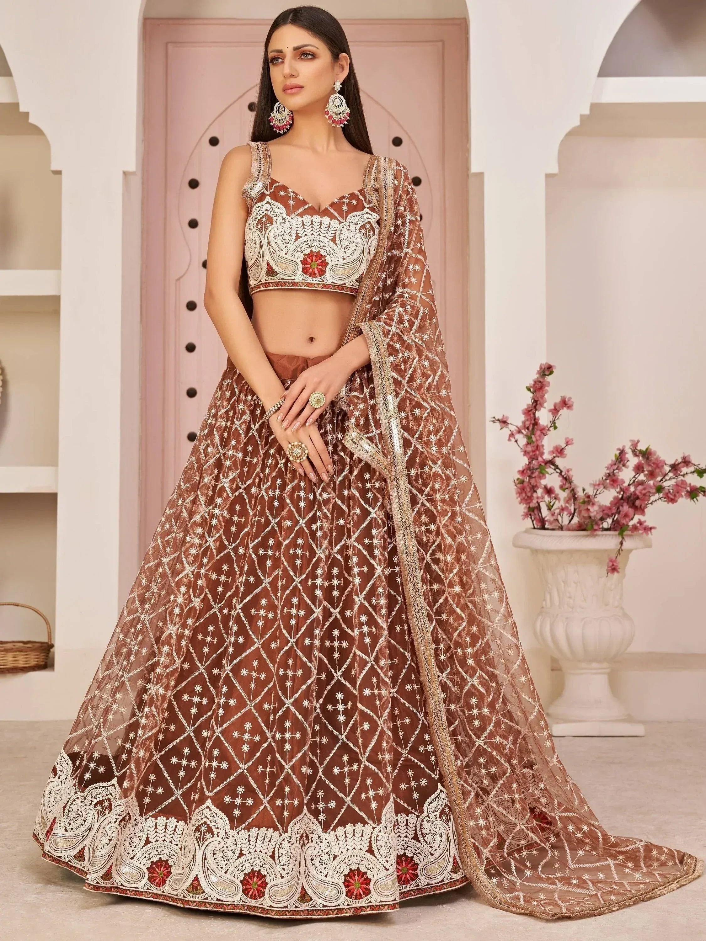 Elegant brown lehenga choli with intricate white embroidery and floral motifs, perfect for Indian ethnic wear.