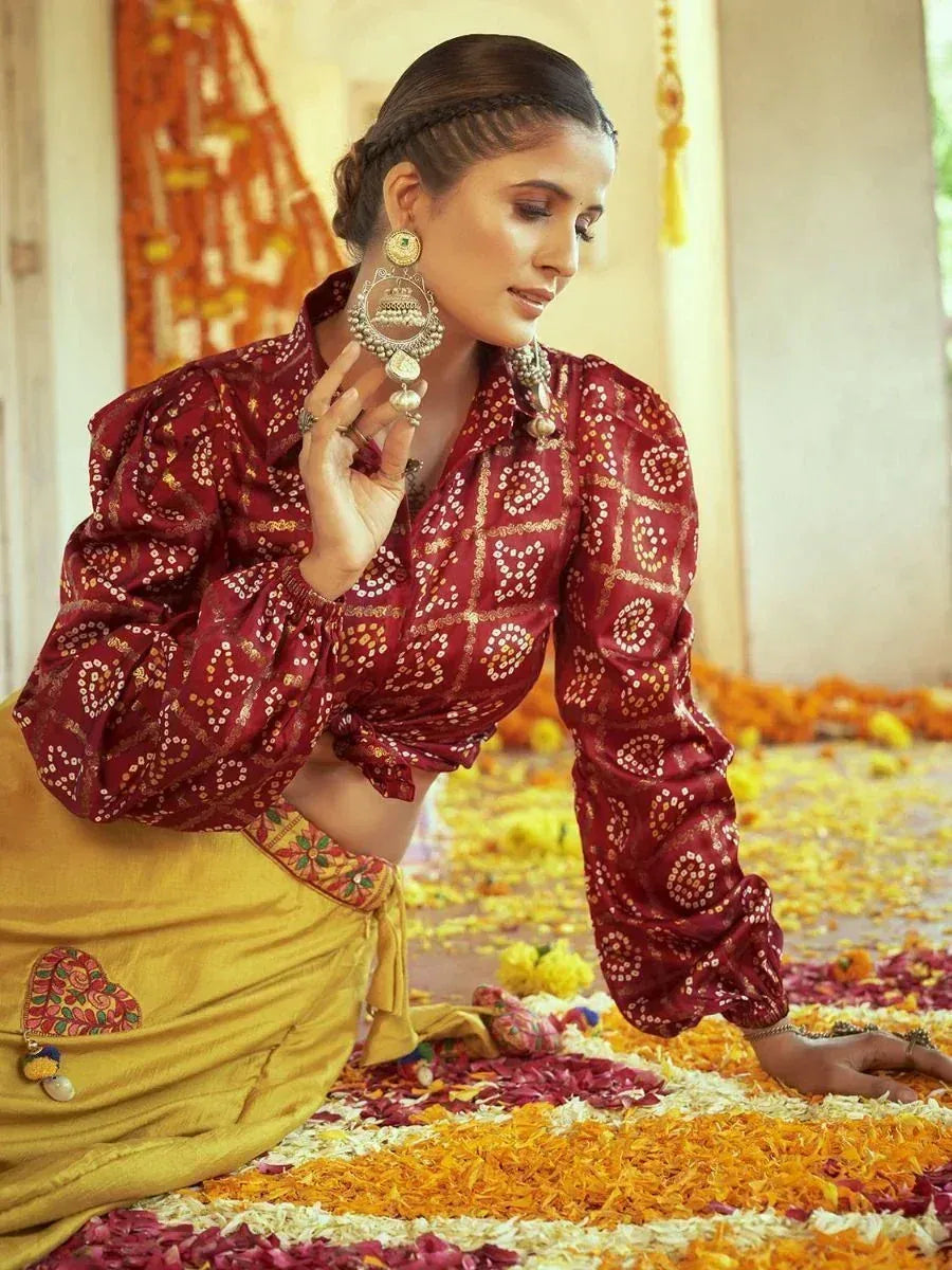 Woman in maroon printed blouse and yellow skirt with floral petals, traditional Indian ethnic wear