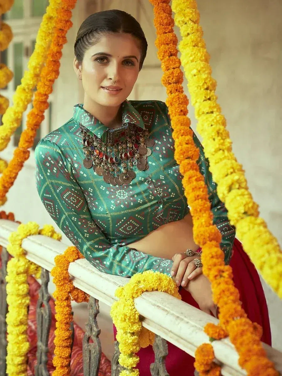 Woman in green printed ethnic blouse with coin necklace, marigold garlands, red skirt