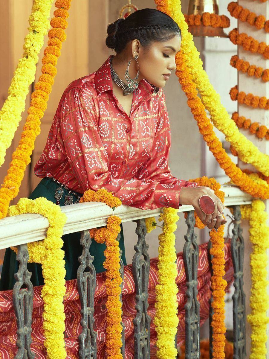 Woman in red printed ethnic blouse with marigold garlands, traditional Indian attire