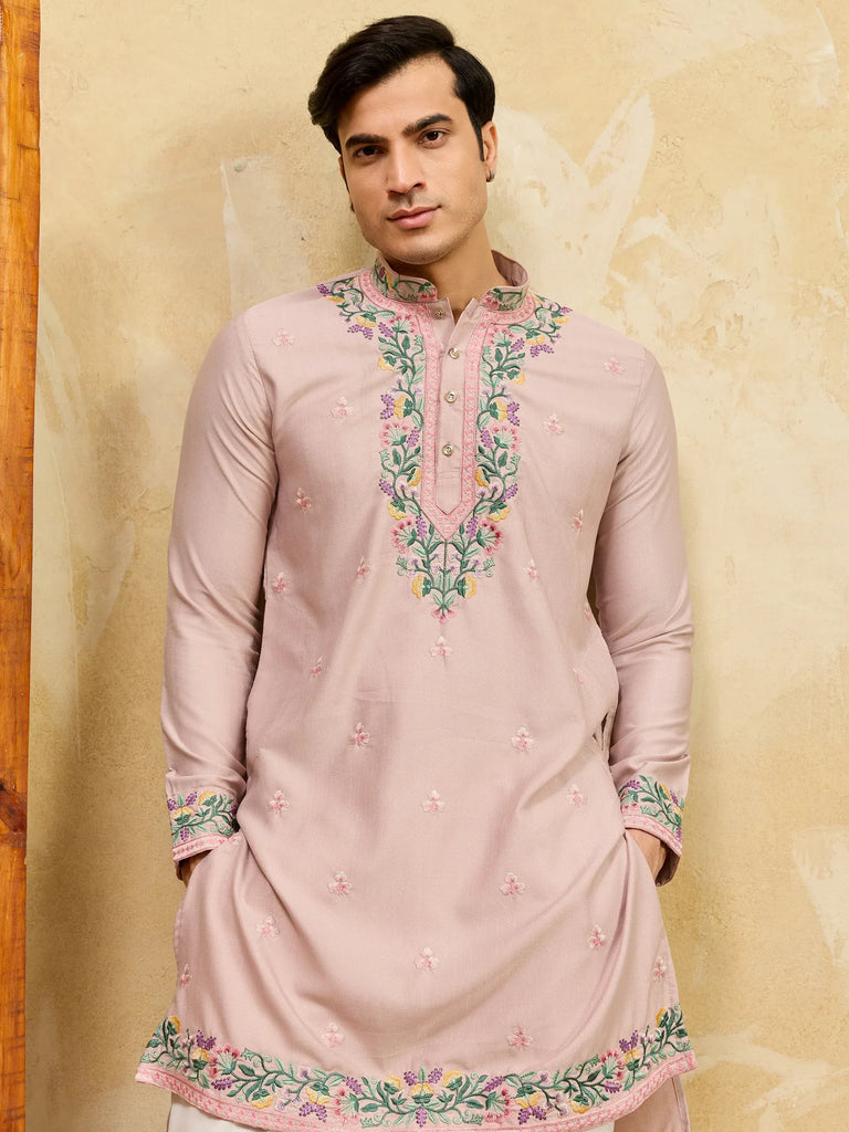 Man wearing a dusty pink embroidered Indian ethnic kurta with floral patterns