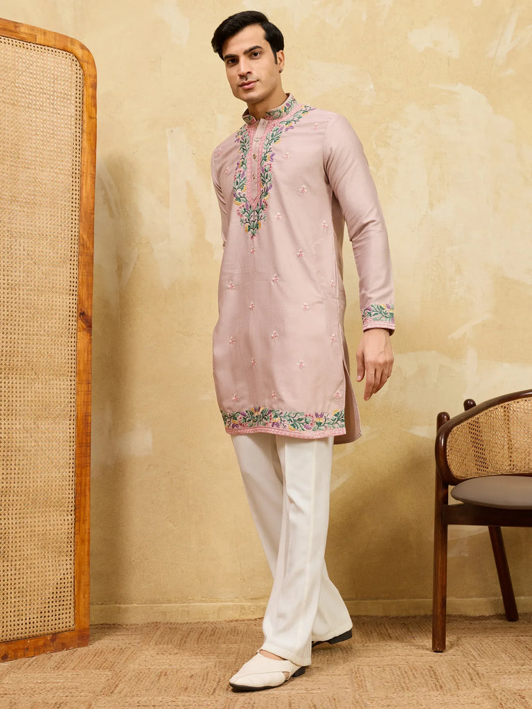 Man wearing a pink embroidered kurta with white pajamas