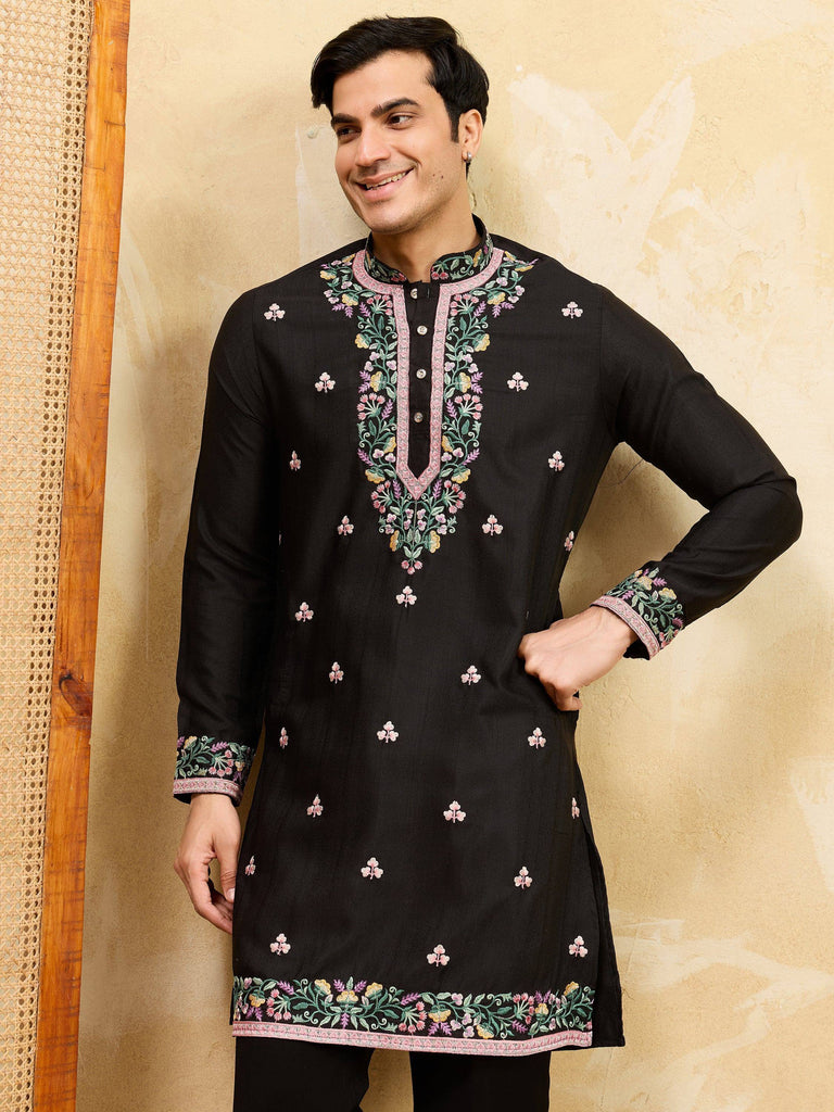 Man wearing a black embroidered Indian ethnic kurta with floral designs.