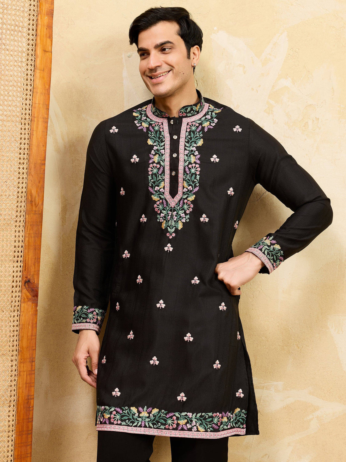 Man wearing a black embroidered Indian ethnic kurta with floral designs.