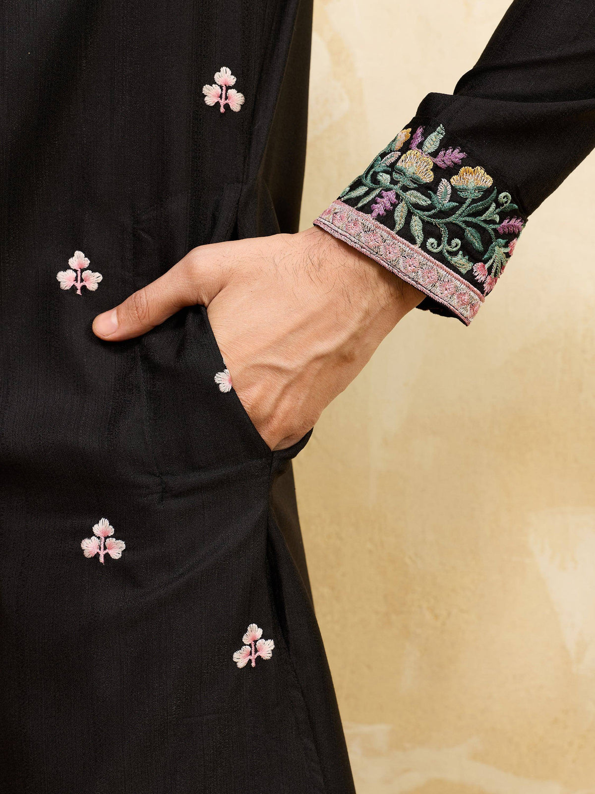 Close-up of a black ethnic kurta featuring floral embroidery on the sleeve and body.