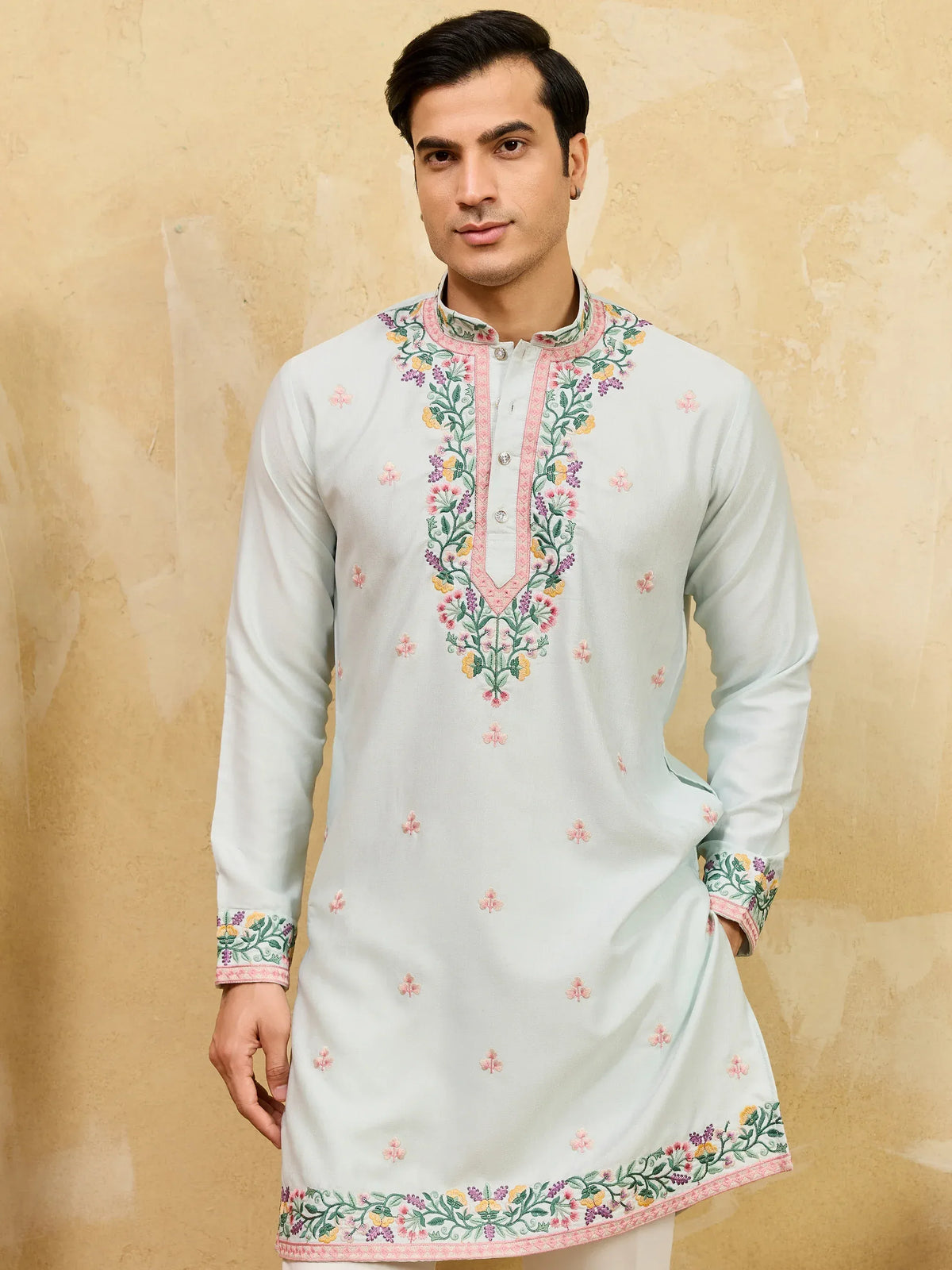 Man wearing a light blue embroidered ethnic kurta with floral patterns