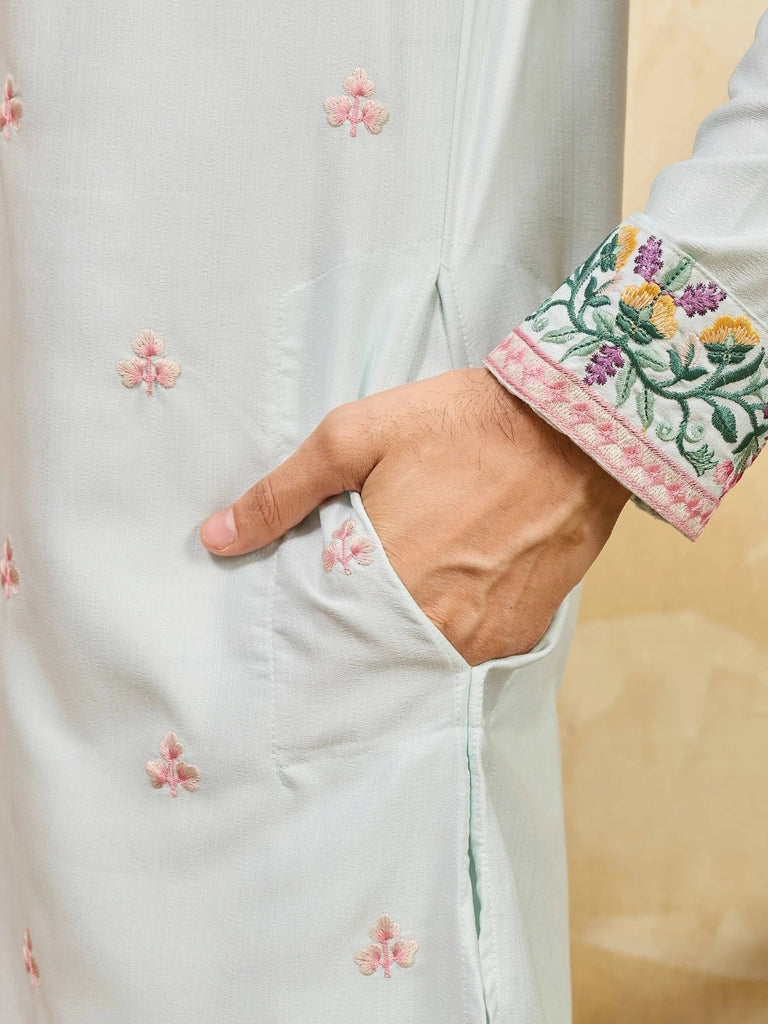 Close-up of a light blue men's ethnic kurta with floral embroidery and a decorative cuff.