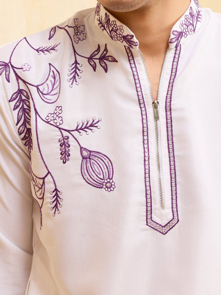 Close-up of a white men's ethnic kurta with purple floral embroidery and a zipper neckline.