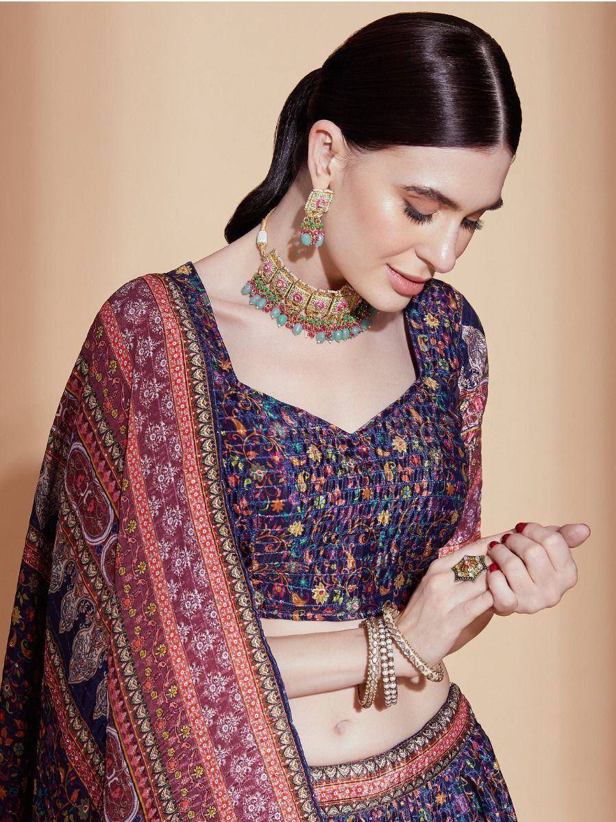 Woman in colorful printed lehenga choli with ethnic jewelry, showcasing designer Indian ethnic wear